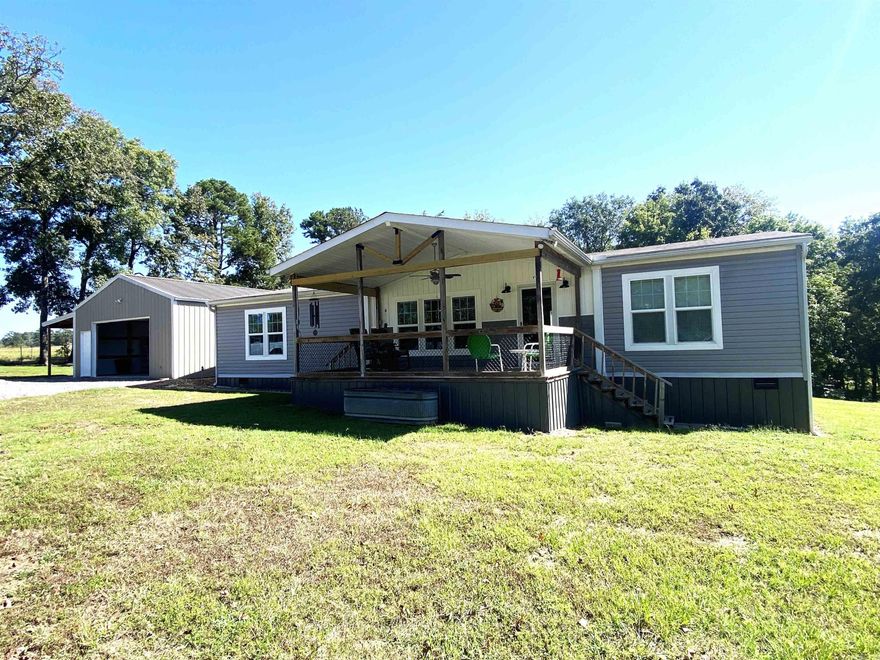 Discover your dream home in this beautifully maintained 2020 doublewide mobile home, perfectly situated on a 3-acre lot. This spacious residence offers the perfect blend of modern comfort and serene country living. This 3BR/2BA property with bright and airy living room seamlessly flows into the dining area and kitchen, ideal for entertaining. Kitchen is equipped with modern appliances, ample cabinet space, and a large island for cooking and gatherings. Generous master bedroom with en-suite bathroom featuring a soaking tub, double vanity, and a beautiful walk-in shower. Detached shop is 24x32 with a 8ft lean-to equipped with electricity.  8x8 safe room in shop.  Fenced backyard for your pets with covered decks on front and back with fans to enjoy the outdoors. Don't miss this beautiful property!!