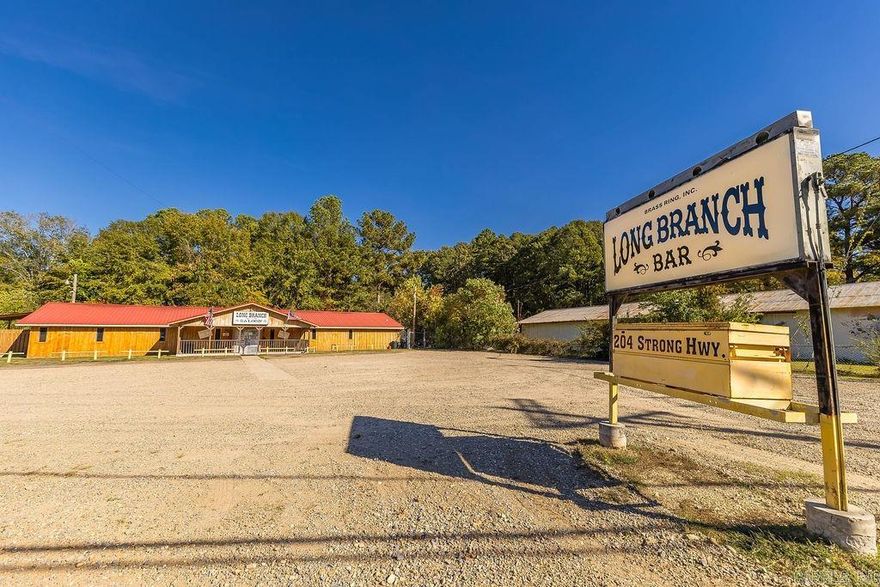 A rare opportunity to own The Long Branch Bar & Saloon, one of El Dorado’s most recognizable gathering spots on high-traffic Strong Hwy.   The property has been meticulously maintained with numerous updates and features a commercial kitchen, karaoke and dance floor, pool tables, and areas historically used for live music and entertainment. Per seller, the property has previously operated with a tobacco permit and amusement license supporting karaoke and other activities. Per seller, it has also historically benefited from a grandfathered allowance permitting alcohol service after 2AM. Buyers must verify all licensing, zoning, and operational requirements with the proper authorities.  Situated on approx. 0.89 acres with ample parking, a metal roof, central HVAC, and a well-known local presence, this property offers tremendous potential for continued venue use or other permitted commercial purposes. Private showings only. Buyer to verify all square footage, acreage, utilities, and permitted use.
