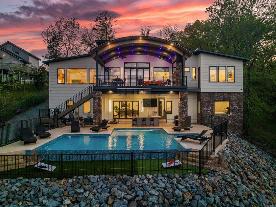 Welcome to an unparalleled masterpiece on the shores of Lake Hamilton—one of the most sought-after destinations in Hot Springs,Arkansas. This remarkable luxury lake home is not only one of the top-performing nightly rental properties in the area but also an idealretreat for weekend getaways or a prestigious primary residence. Designed to impress the most discerning buyers, this sophisticated“Smart Home” seamlessly blends high-end appointments with cutting-edge technology, setting a new standard for luxury living. As youopen the commanding front doors, you’re immediately captivated by sweeping lake views framed by a stunning custom barrel ceiling—atrue testament to the builder’s exceptional craftsmanship. Every inch of this home is meticulously designed to offer an opulent yetwelcoming atmosphere, perfect for both relaxation and entertainment. The heart of this home is its incredible kitchen, equipped withDekton countertops that are as durable as they are beautiful, Rift-sawn red oak cabinets with a sleek, modern aesthetic, PremiumGerman steel faucets, marrying form and function, and A state-of-the-art Miele built-in coffee maker, perfect for the ultimate morningindulgence. Nestled