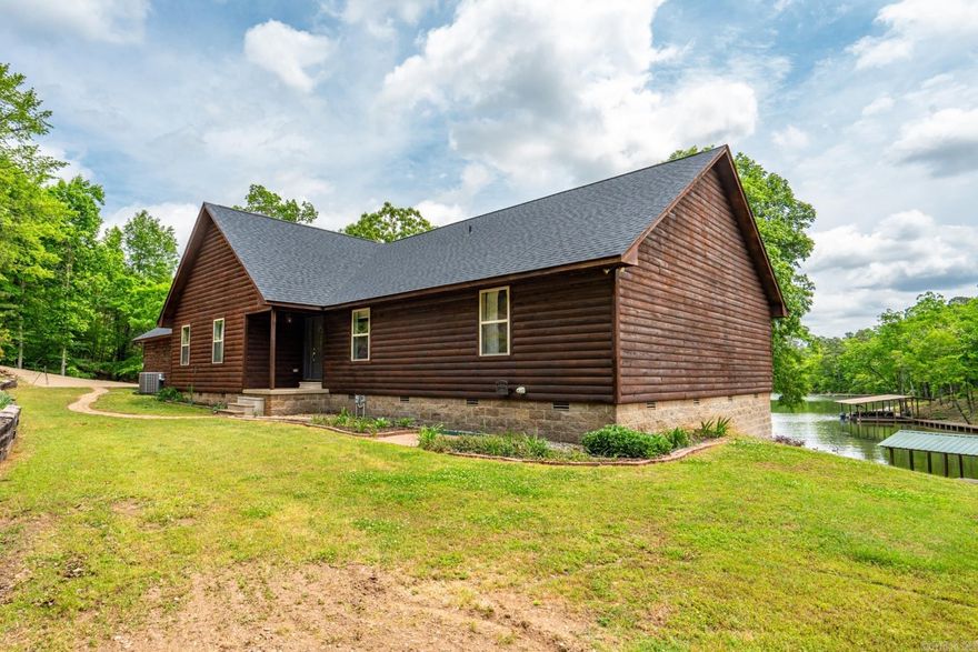 Just 20 minutes from Lake Ouachita, situated on a hill top above the waters edge this beautiful modern log cabin home features a serene environment at the end of a long winding driveway giving you a quiet oasis on the edge of Lake Hamilton.  The exterior is sporting a deep tone log siding atop contemporary stone on the back side.  The large open floor plan is perfect for entertaining, vaulted ceiling in the great room with floor to ceiling windows gives you a birds eye view of the water.  The master suite features a jetted soaking tub and walk in shower.  Walk in closets, built ins and recessed lighting can be found throughout this beautiful family home.  The back deck will be your favorite place to relax from stunning sunsets to star gazing, welcome to summer...welcome to your new home!