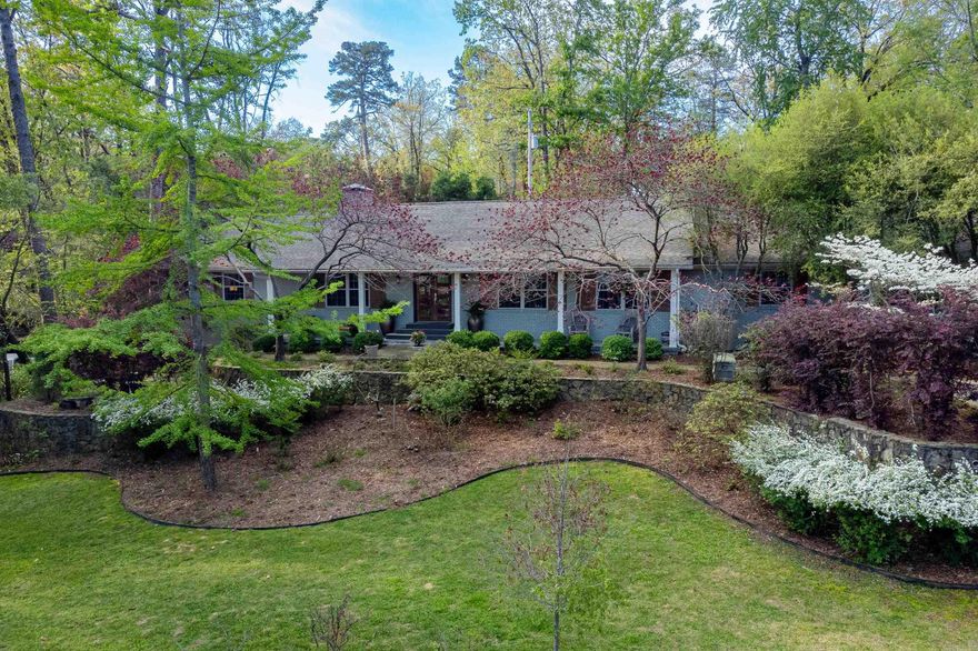 Gorgeous traditional home with mid century modern touches nestled on beautifully landscaped oversized lot. Artistry and craftsmanship shines through the hardwood floors, impressive millwork and massive stacked stone WBFP. Fabulous kitchen with quality walnut cabinetry, tons of slab granite counters and entertaining areas. Formal and informal dining areas and handsome study/office as well as huge bonus/studio workshop. Primary suite with luxurious bath and two large closets. Three nice sized guest bedrooms and two baths apart. Charming front porch as well as covered and uncovered back patios and landscaping. Rear and side parking pads in addition to 2 car carport. Come see!