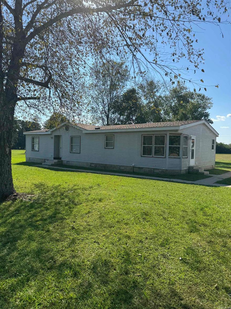 3/2 bath double wide home on permanent foundation that sets on 3.06 beautiful acres m/l. 21 x 27 shop with electric and garage door opener.  Additional shed with lean-to would make a great storage building for implements or animals.  This home has had a new roof installed 2 years ago both on house and shop.  New HVAC unit was installed 2 years ago also.  Many upgrades in home includes newer appliances, new shower installed and rooms painted about 2 years.  The home is surrounded by concrete walkways that lead to a porch that was installed around 2022.  Don't wait this one will not last long.  House is being sold AS IS.  Agent see remarks