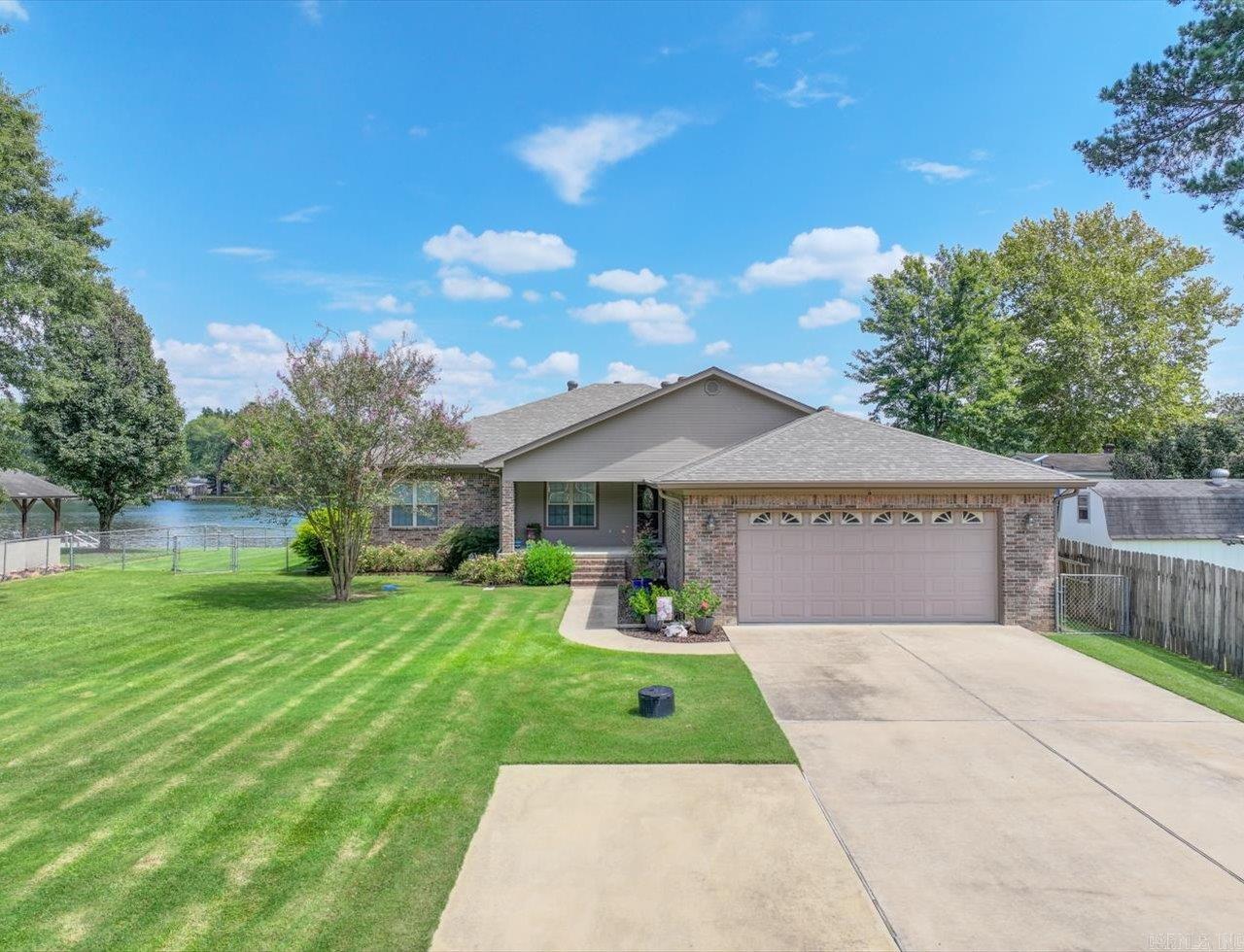 Wake up to one of the most beautiful sunrises on Lake Hamilton! This well maintained, custom built home with a wall of windows right on the shores of Lake Hamilton has been enjoyed by the same family since they designed and built in 2006. Too many features to list, but here are a few; large screened in porch right at the waters edge, swim dock with stairs into lake on the lake side, boat dock and double jet ski lift on the street side, 13X30 SBI metal storage building, Lorex Security system with cameras, a tornado shelter, lake fed irrigation system. Interior features include tile and 3/4" hardwood floors, a chef's kitchen with appliance garages, mixer lift, butane cooktop and hickory cabinets with room for all your cooking essentials. Split floor plan with open concept kitchen, dining and living area. This home has an office and a small room that could be used as a bunk room. The two car garage is oversized and features a floored attic with extra insulation. New roof, gutters and exterior paint 2024. If you're looking for an exceptionally maintained home on a flat lot on beautiful Lake Hamilton, this is the one!