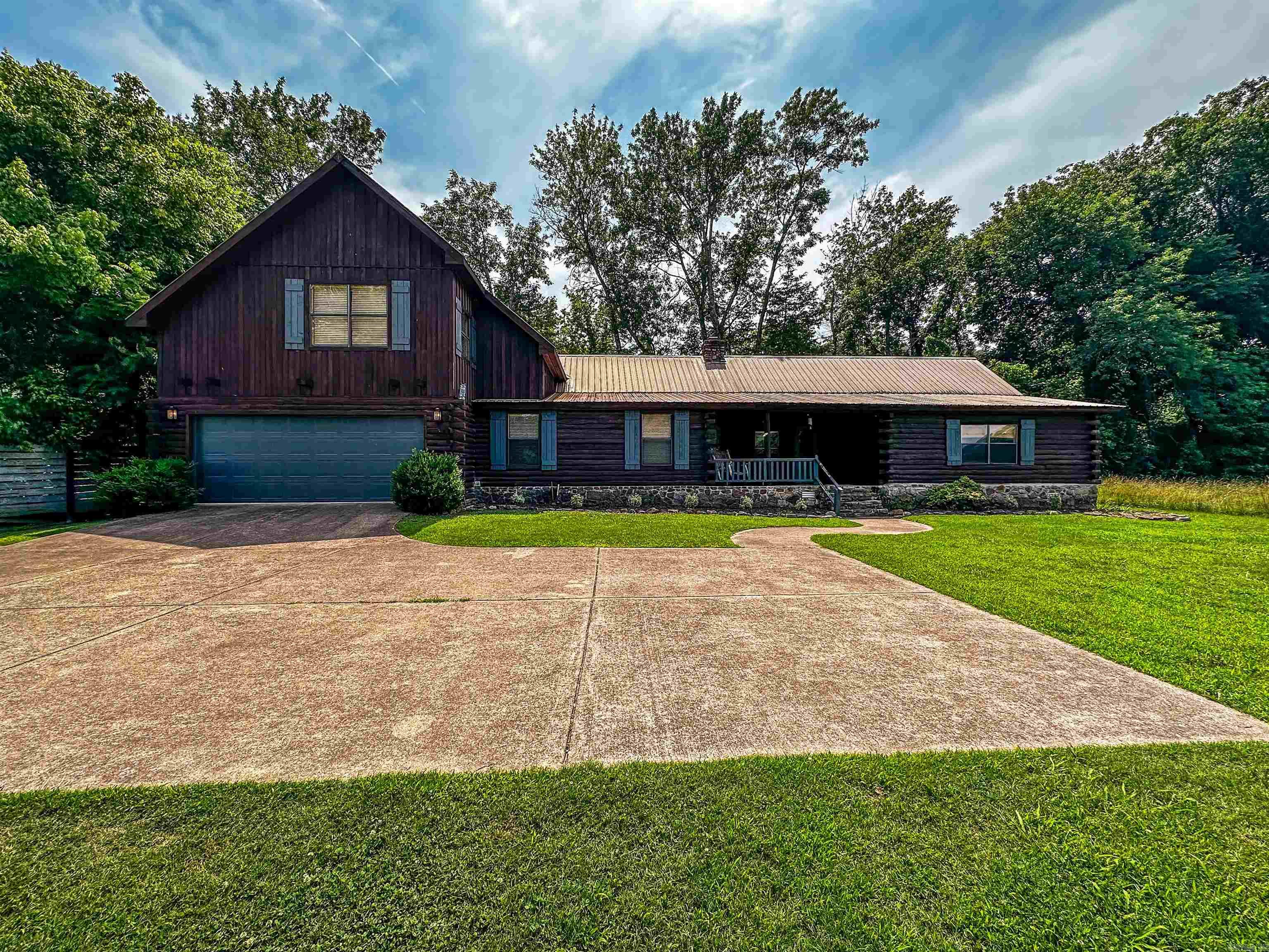 No. 025035 For $575,000, own this stunning multi-level 5-bedroom, 3-bath log cabin nestled on the banks of the White River in Mountain View, Arkansas. With 3,445 sq ft of space, this peaceful retreat offers big porches, a screened-in porch, and a deck overlooking the river. Inside, enjoy two full kitchens, including a galley-style kitchen with river views. The cabin can be divided into two units, making it ideal for nightly rentals. A spacious great room sits above the two-car garage, perfect for a large sleeping area or entertainment space. The master suite features two vanities, and the home comes partially furnished to continue as a successful VRBO or Airbnb. Walk to the river and enjoy the tranquility of this one-of-a-kind riverside escape.