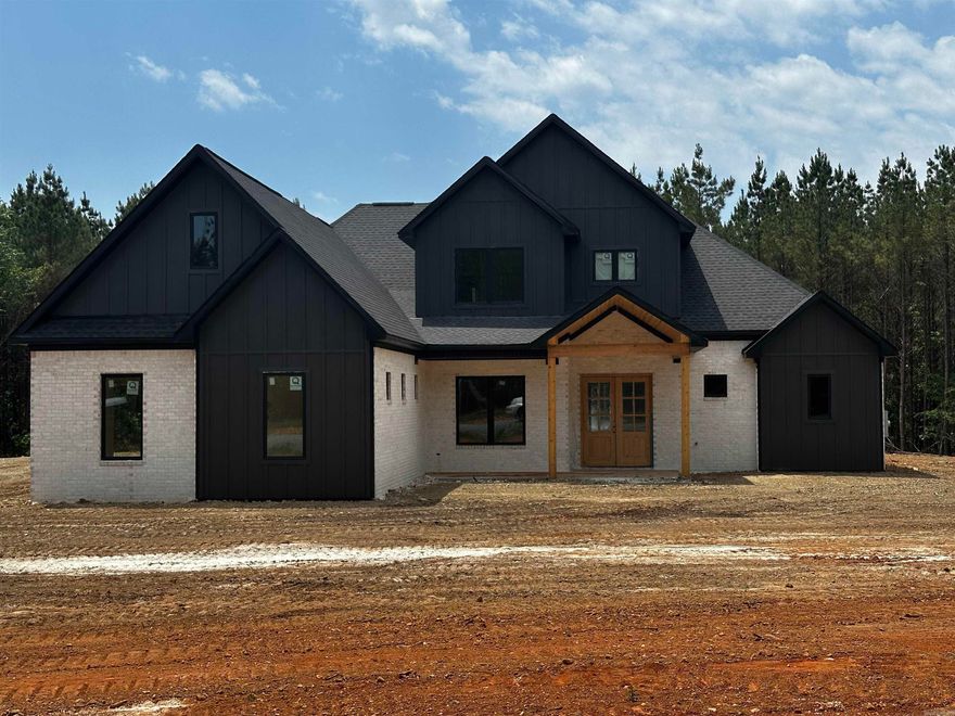Set on over 8 acres, this stunning new construction home offers the perfect blend of luxury, privacy, and thoughtful design. With approximately 3,900 sqft, this home delivers exceptional space. Inside, you’ll find 5 bedrooms, 3.5 bathrooms, a dedicated office, with a large bonus room, including two en-suite bedrooms on first floor—perfect for guests or multigenerational living. The main living area features a cozy gas fireplace and opens seamlessly to the outdoor living space through a dramatic 12-foot sliding door, creating the perfect setting for entertaining.  The kitchen is designed for both function and style with a gas range, abundant storage, and a separate butler’s kitchen/pantry that makes hosting effortless.  The spacious primary suite is a space of its own, featuring a luxurious bath with a pass-through walk-in shower and freestanding soaking tub, custom storage, and thoughtful toe-kick lighting. With acreage, luxury finishes, and modern efficiency, this home offers a rare opportunity to enjoy space, comfort, and refined country living without sacrificing style or convenience. Minutes from the interstate and zoned for Benton Public Schools. Agents- See remarks