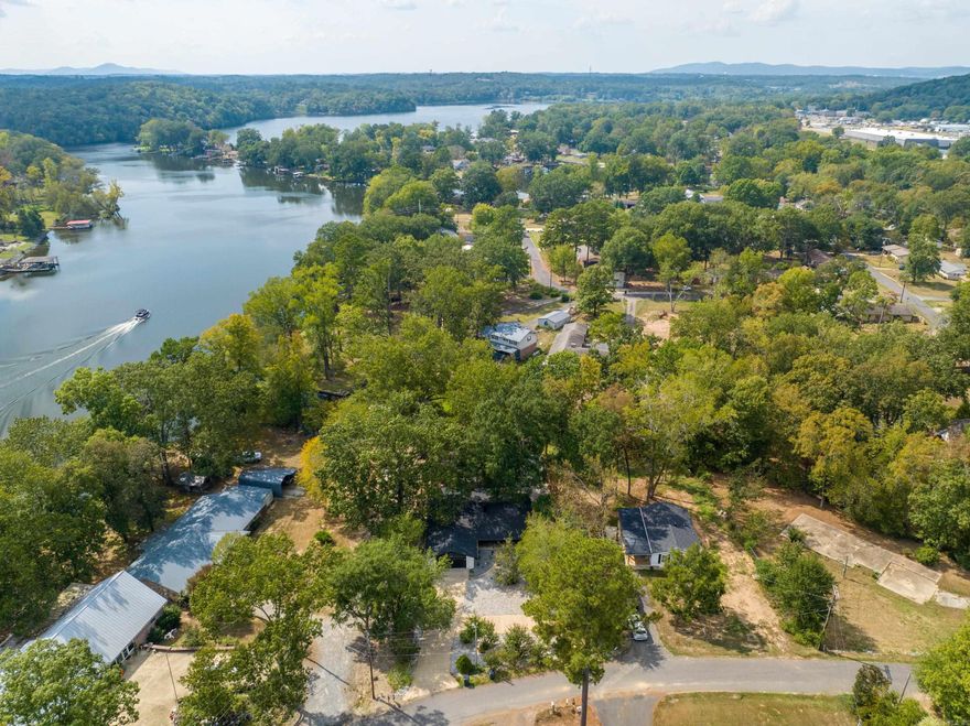 This beautifully updated home offers lakefront living at its finest, featuring an open concept layout, a covered boat dock, and modern upgrades, including a new roof, HVAC, and state of the art appliances. The neighborhood includes a private boat ramp, adding even more convenience. Enjoy outdoor living with a spacious deck, patio, and a 19x9 storage building, perfect for storing lake toys, kayaks, or outdoor gear. Conveniently located 5 minutes from the MLK bypass, 6 minutes from Lakeside schools, and 10 minutes from Bathouse Row, this property is close to shopping and dining. Currently a short term rental, it's available fully furnished with high end contents included with an acceptable offer. Call today to see this turnkey lakefront retreat!