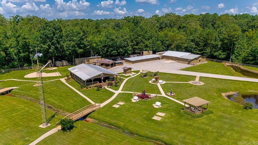 This is one incredible property and a once in a lifetime chance to own your own family complex. in-laws, guests, rental, family.business retreat, you decide.  Fully fenced 5.6 acres.  3 homes, Mini living suite.Office, work shop/garage, huge Open Air Pavilion (2 air conditioners, 26 ceiling fans, raised stand for performing, electrical outlets), Serving Pavilion, and a 3rd pavilion for all your entertaining needs.   More buildings, Large enclosed  garage storage areas, play yard,  storage buildings, in-ground storm shelter,  ponds and more. Professionally landscaped. 100 thousand watt generator in fenced area behind the home which is connected to all the residences. The list goes on and on.  Ask for a complete list.  You will not find another property like this one.