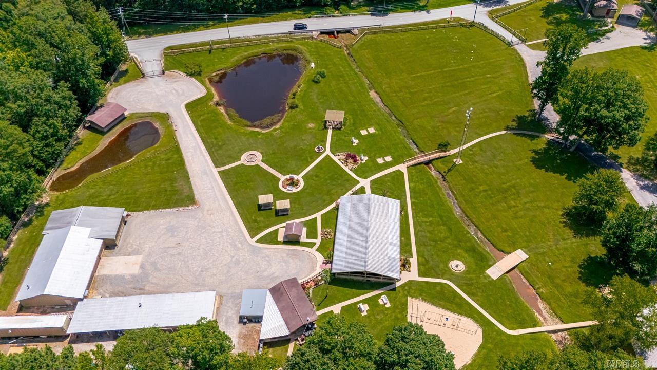 This is one incredible property and a once in a lifetime chance to own your own family complex. in-laws, guests, rental, family.business retreat, you decide. Fully fenced 5.6 acres. 3 homes, Mini living suite.Office, work shop/garage, huge Open Air Pavilion (2 air conditioners, 26 ceiling fans, raised stand for performing, electrical outlets), Serving Pavilion, and a 3rd pavilion for all your entertaining needs. More buildings, Large enclosed garage storage areas, play yard, storage buildings, in-ground storm shelter, ponds and more. Professionally landscaped. 100 thousand watt generator in fenced area behind the home which is connected to all the residences. The list goes on and on. Ask for a complete list. You will not find another property like this one.