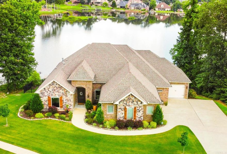 Discover the epitome of lakeside luxury at this stunning custom home nestled on the shores of Hurricane Lake. Designed for seamless single-level living, the residence features 4BR and 3BA on the main level. 12-foot ceilings adorned with wood beams and expansive walls of windows that frame captivating lake views. A striking stone fireplace anchors the living room, while the gourmet kitchen is equipped with an island boasting a built-in wine rack, a stone vent hood, and a walk-in pantry. The adjoining breakfast area and formal dining room provide ample space for entertaining guests. The primary suite is a serene sanctuary with a bay window overlooking the water, a double-sided fireplace, and a generously sized walk-in closet. Additional bedrooms offer huge closets and hardwood floors. Mudroom with built-ins and spacious laundry room. Downstairs, a versatile bonus room includes a wet bar and media room (or potential 5th bedroom), accompanied by a storage room featuring a storm shelter. Outside, the expansive fenced backyard is complete with a picturesque gazebo, sprinkler system, retaining wall, storage room, and a private dock! Lot is very private with woods on either side!