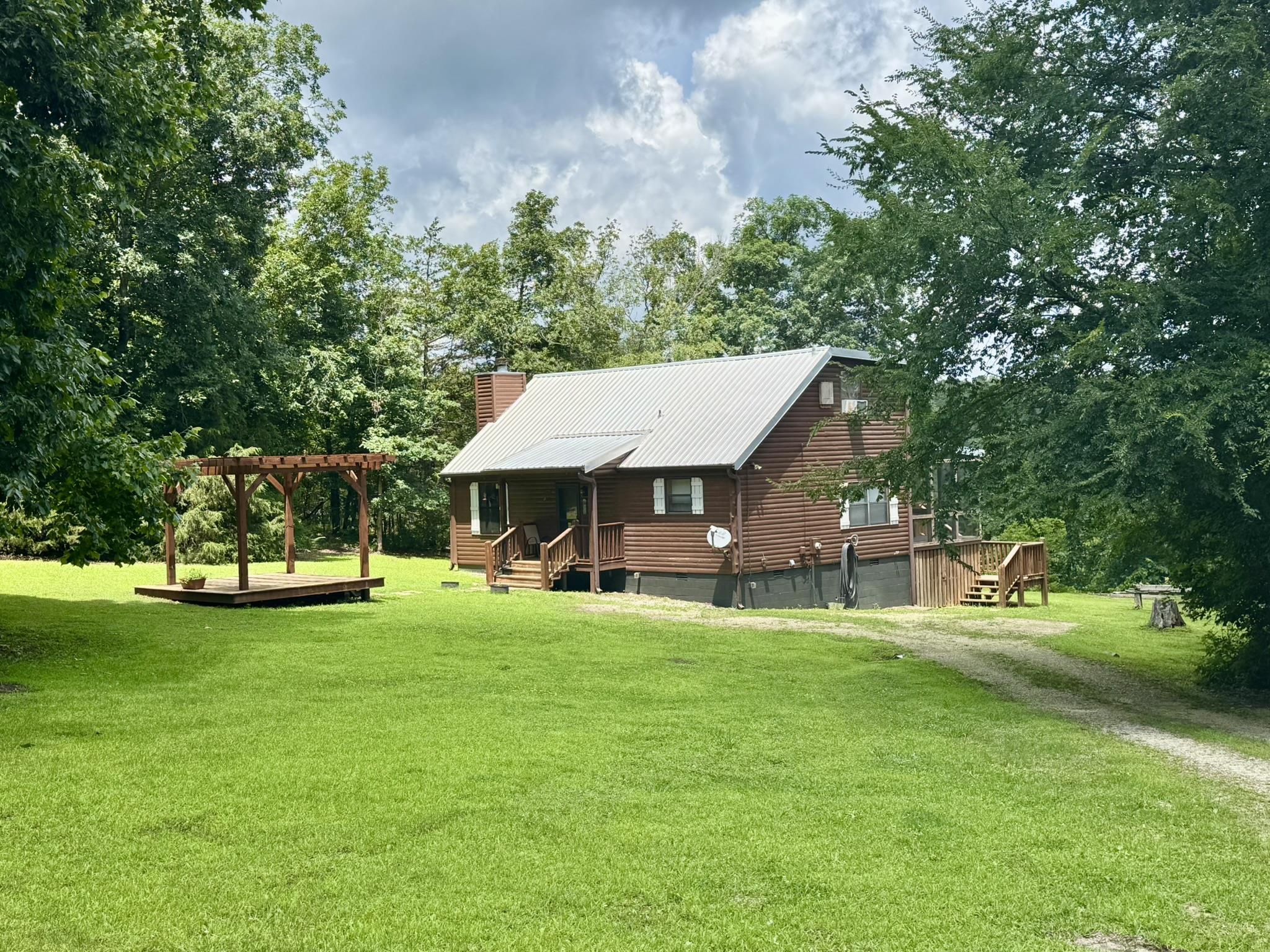 Beautiful cabin on 3.33 acres in the Mount Olive community, overlooking the beautiful White River!! This 2-bedroom, 1.5-bath home features an open floor plan with vaulted wood ceilings, a wood-burning fireplace, and an open kitchen with stunning cabinetry. Comes fully furnished and move-in ready. Enjoy the outdoors from the screened-in porch, back deck, or under the pergola. A separate storage building conveys with the property. Perfect for a peaceful getaway, full-time living, or vacation rental!