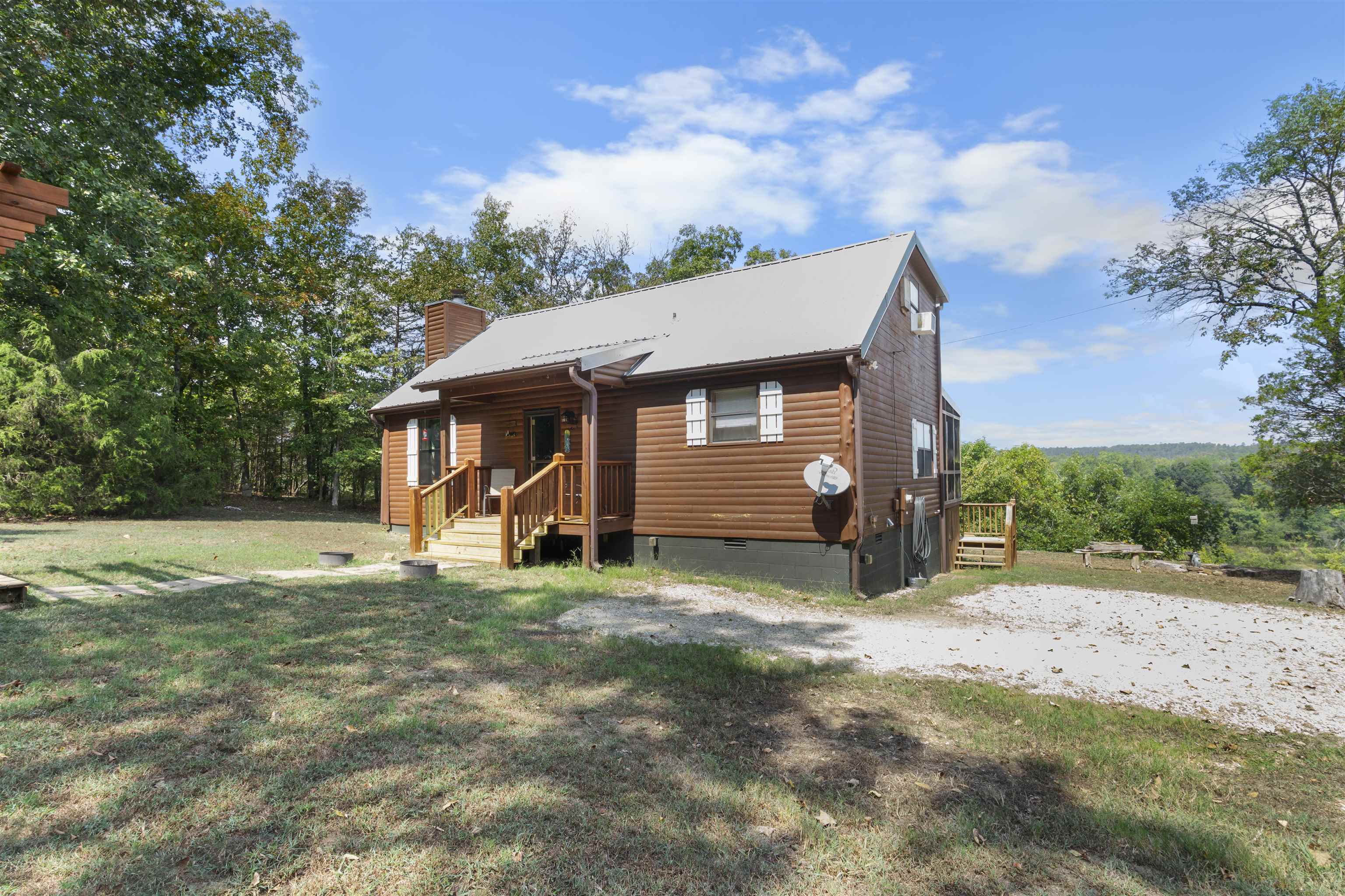 Beautiful cabin on 3.33 acres in the Mount Olive community, overlooking the beautiful White River!! This 2-bedroom, 1.5-bath home features an open floor plan with vaulted wood ceilings, a wood-burning fireplace, and an open kitchen with stunning cabinetry. Comes fully furnished and move-in ready. Enjoy the outdoors from the screened-in porch, back deck, or under the pergola. A separate storage building conveys with the property. Perfect for a peaceful getaway, full-time living, or vacation rental!