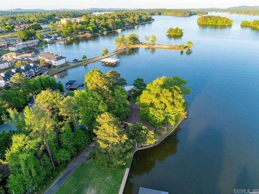 Stop scrolling!! This is the one!. Located on a premium peninsula of Lake Hamilton, this exceptional property boasts over 465 feet of prime shoreline on coveted Lake Hamilton, offering unparalleled water frontage and panoramic lake views. This expansive property is perfectly positioned to capture 180-degree vistas of serene waters, vibrant sunsets, and natural beauty in every direction. The point location provides privacy, tranquility, and unobstructed views that are simply unmatched. The home is a spacious, single-level residence designed to maximize comfort and capture the views. While the true value lies in the land, the home offers: 4 Bedrooms & 3 Bathrooms: Generously sized bedrooms and baths provide ample space for family and guests. This home provides multiple Living Areas, perfect for entertaining or relaxing. The large master suite features breath-taking lake views and a private, tranquil setting. Three-Car Garage provides plenty of storage for vehicles, boats, or recreational equipment. There is an additional storage building for convenience. This home is located less 15 minutes from so many amenities. These include shopping, healthcare, restaurants and Oaklawn casino.