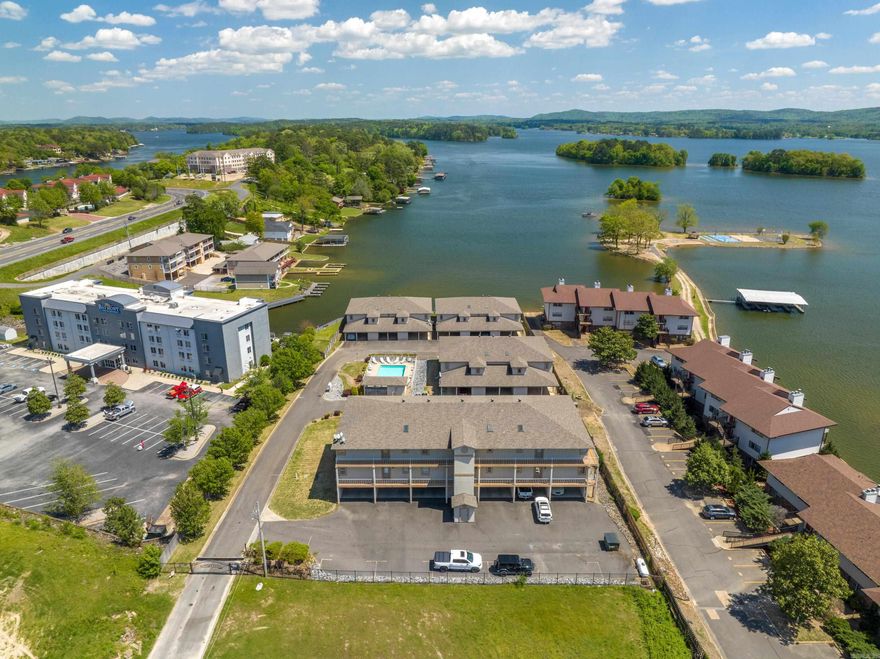 ~Lake days, city nights, 7 South living ~ Enjoy the best of 7-South living in this turn-key, fully furnished condo located just off the shores of Lake Hamilton in the heart of Hot Springs. With 1500+ sqft, this unit offers a spacious, airy layout rarely found in condo living. You'll love the oversized kitchen that flows into the living area with a fireplace and access to a large covered balcony. The expansive balcony provides a true outdoor living space with lake and pool views - perfect for enjoying your morning coffee or evening sunsets. The generously sized primary suite includes private balcony access, a new soaking tub, and separate shower, while guests enjoy their own bedroom and full bath. A separate utility room with washer & dryer adds convenience. This gated community offers elevator access, covered parking, private storage space, and beautifully maintained grounds with pool. Owners may also enjoy use of two shared boat slips for temporary stays (up to two weeks at a time). Sold completely furnished and nightly rentals are allowed, making this an ideal full-time residence, weekend getaway, or investment opportunity in one of Lake Hamilton’s most convenient locations.