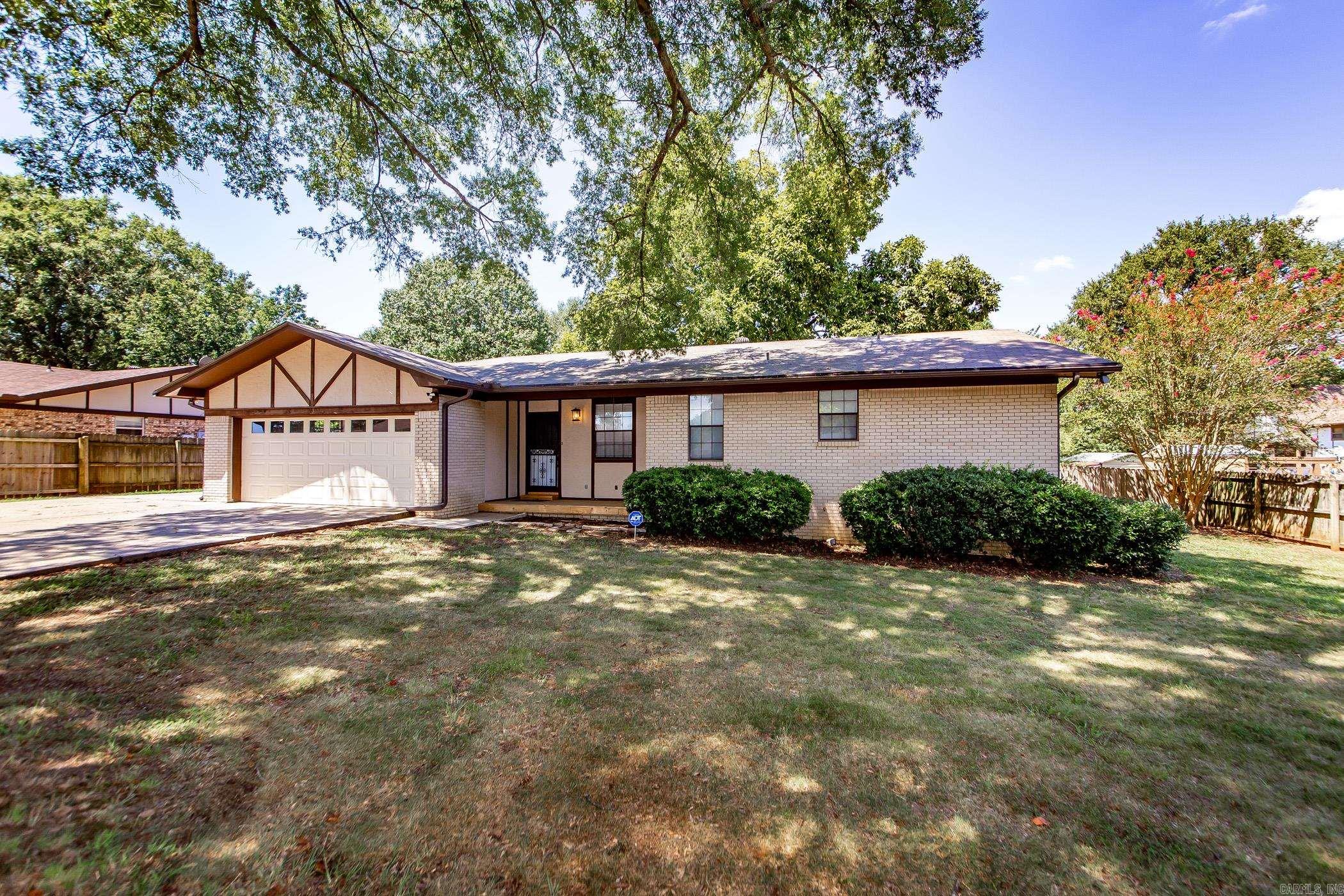 Step inside this beautifully updated ranch-style home that blends classic charm with modern updates. The living room welcomes you with new flooring, fresh paint, and a striking painted brick fireplace that creates a cozy focal point. Tucked in the living room is a wet bar with room for a mini fridge- creating the perfect entertaining space! The open dining and kitchen area features stainless steel appliances, ample cabinet space, and warm hardwood floors—perfect for both everyday meals and family gatherings. The oversized primary suite offers plenty of room to relax and includes a private bath with 2 separate vanities and closets. While additional bedrooms are generously sized with great closet space separated by a full bath with double vanity and walk in shower. Don’t miss the bonus mud room/office with exterior door leading to extra parking pad with RV parking! Step outside to enjoy the shaded backyard, mature trees, and a deck ideal for hanging out and enjoying the peaceful yard. With an attached 2-car garage, fresh interior updates, and thoughtful finishes throughout, this home is move-in ready and waiting for its next chapter! New Roof 2021 Two New HVAC 2023 Remodel 2025