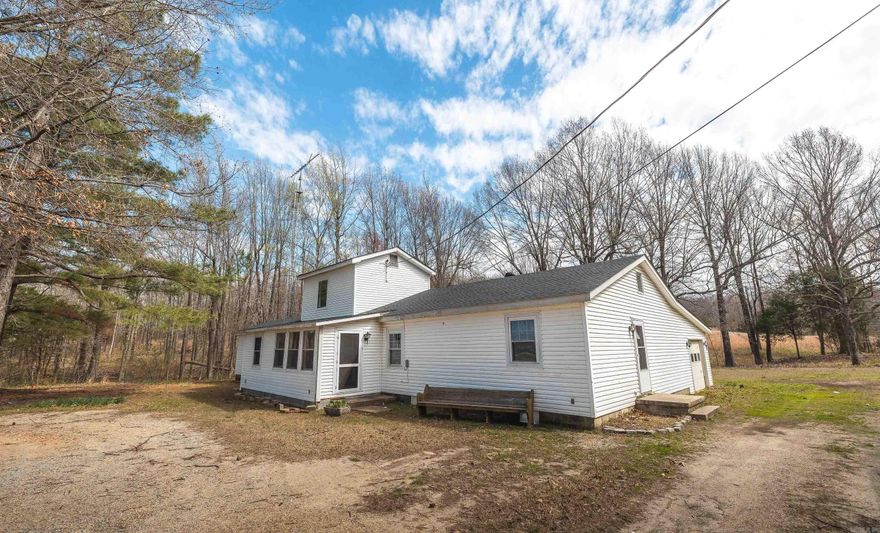 Welcome to country living at its finest just outside of McDougal! Situated on 6± beautiful acres along the foothills of Crowley’s Ridge, this 4 bedroom, 2 bathroom home offers 2,296± SF of comfortable living space with the perfect blend of open land and mature timber.  Approximately 2 acres are cleared, providing a spacious yard ideal for recreation, gatherings, or simply enjoying the outdoors, while the remaining 4 wooded acres offer privacy, shade, and opportunities for exploring or wildlife watching. A small creek runs through the property, adding to the peaceful, natural setting.  The home has seen numerous updates, including new flooring and fresh paint, while still leaving room for you to add your own finishing touches. An attached workshop/garage provides convenience for projects or storage, and the 30x24 detached utility building with a garage door offers even more space for equipment, tools, or hobbies. An additional outbuilding makes a perfect lawn or garden shed.  Positioned to capture stunning sunset views, this property overlooks the rich farmland of western Clay County while sitting near the rolling hills—truly offering the best of both worlds.