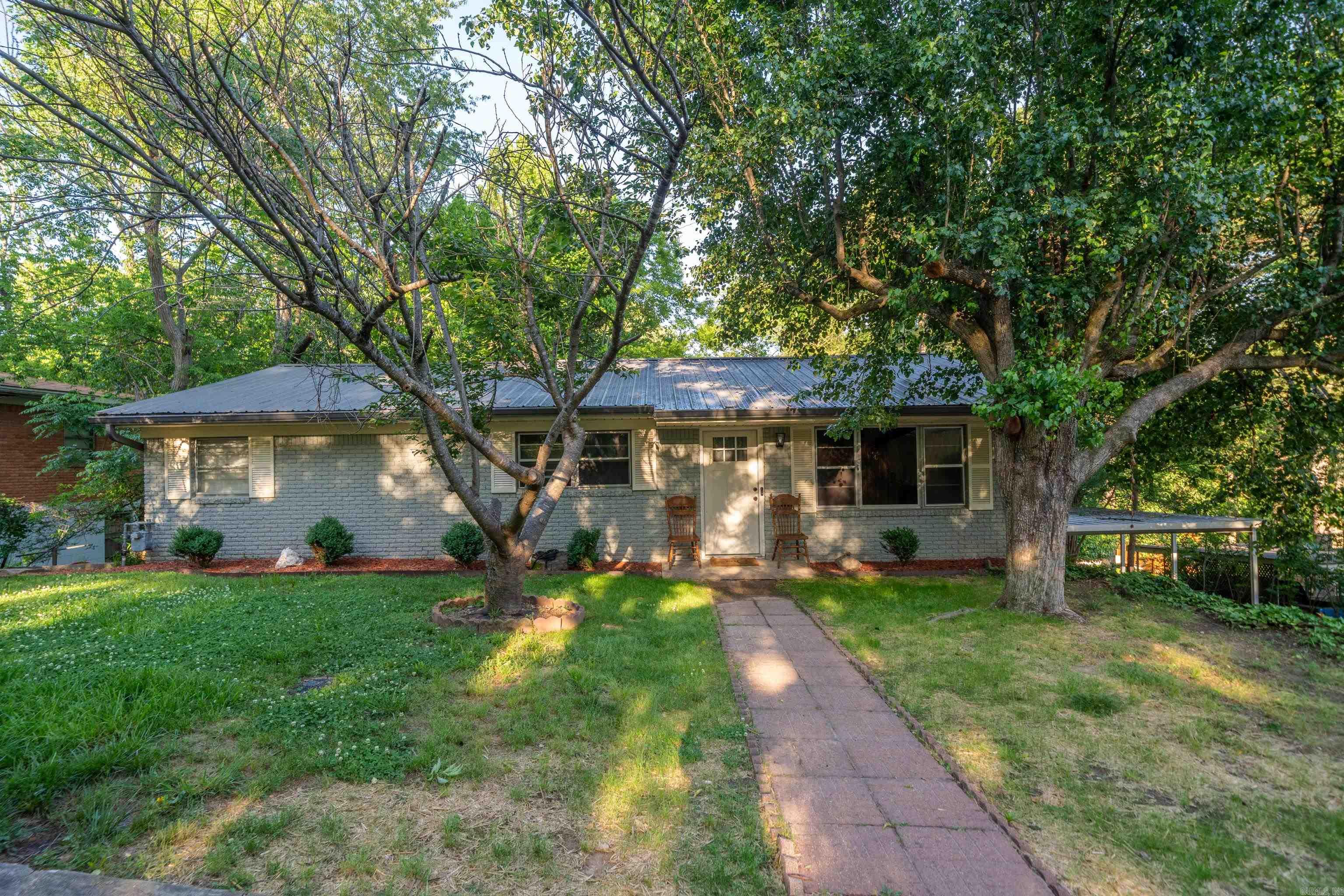 This beautifully remodeled 3-bedroom, 2-bathroom home in Hot Springs offers 2,726 sq ft of living space on a 0.36-acre lot. The main level features 2 bedrooms and a luxurious walk-in shower. The finished basement includes a spacious bedroom, full bath, mini kitchen, and ample closet space—perfect for multi-generational living or entertainment. Recent updates in 2022 include a new metal roof, modern finishes, and an above-ground pool. Additional amenities include a carport, patio, and outdoor storage. Located in the Whitfield subdivision with creek views and no HOA fees.