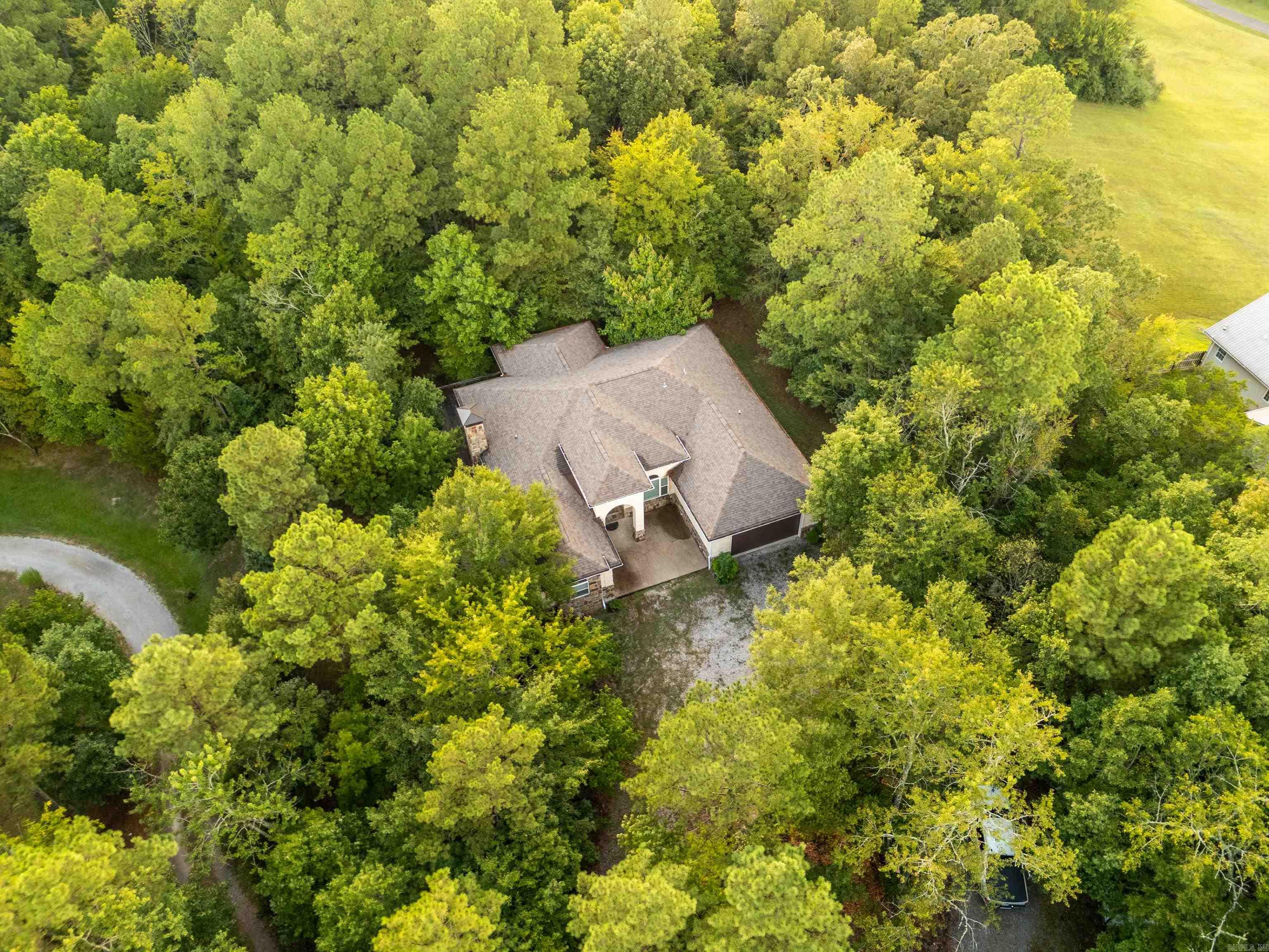 Discover this beautiful private home nestled on 6 wooded acres, just minutes from Lake Hamilton Schools. With 5 bedrooms, 4bathrooms, and multiple living spaces, this home offers room for everyone-plus the perfect layout for entertaining. The main level features a spacious kitchen with breakfast area and an open dining room, and a large main suite with private bath. Two additional bedrooms and bathrooms are also on the main floor, along with a versatile room that can serve as an office or extra bedroom. Downstairs you will find a generous entertaining space complete with bar, woodburning fireplace, plus another bedroom and full bath-ideal for guests or multigenerational living. Step outside to a peaceful deck surrounded by trees and nature, your own private retreat!