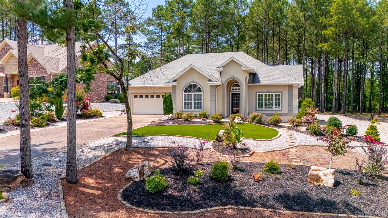 Welcome to golf course living in Hot Springs Village! Located in the desirable East Gate area, this beautifully maintained home is packed with upgrades and perfectly positioned to enjoy the best of the Village lifestyle. Relax in your 10x20 Arkansas room with peaceful views of trees and fairways, or step onto 20x20 covered Trex deckāideal for morning coffee or entertaining guests. Unwind in the hot tub or swim spa under the shaded 10x20 pergola, all while watching golfers tee off right in your backyard! Inside, you'll find stylish updates including Coretec Explorer Oak flooring in the entryway, living area, and primary suite. The roof was replaced in 2018, and every detail has been thoughtfully cared for. Enjoy access to 9 golf courses, 12 lakes, scenic trails, and all the incredible amenities this gated community has to offer.