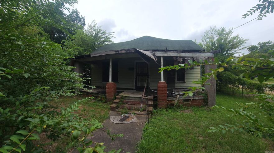 Investors get this fixer upper on 2 lots located near downtown.