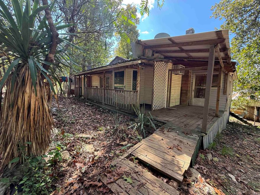 5.4 Acres m/l with Home, Workshop, and Outbuildings – Needs Work but Full of Potential Situated on 5.4 acres m/l, this property includes a roomy 3 bedroom, 2 bath home with decking along nearly all sides. Portions of the decks show wear and will need attention. Inside, the home offers plenty of space and potential, though updates and repair work are needed throughout. An outdoor kitchen area is located on the back deck. The property includes several outbuildings: two storage sheds, a machine shed, a well house, an older camper, and another structure that could serve as a barn once a new roof and finishing work are completed. A large workshop with water and electric is also on site, though it will benefit from repairs. The acreage supports abundant wildlife, including deer, turkey, and squirrels, and is just about 5 miles from the Spring River, known for its world-renowned trout fishing. With multiple improvements already in place, this property presents a project with a variety of features to work with.