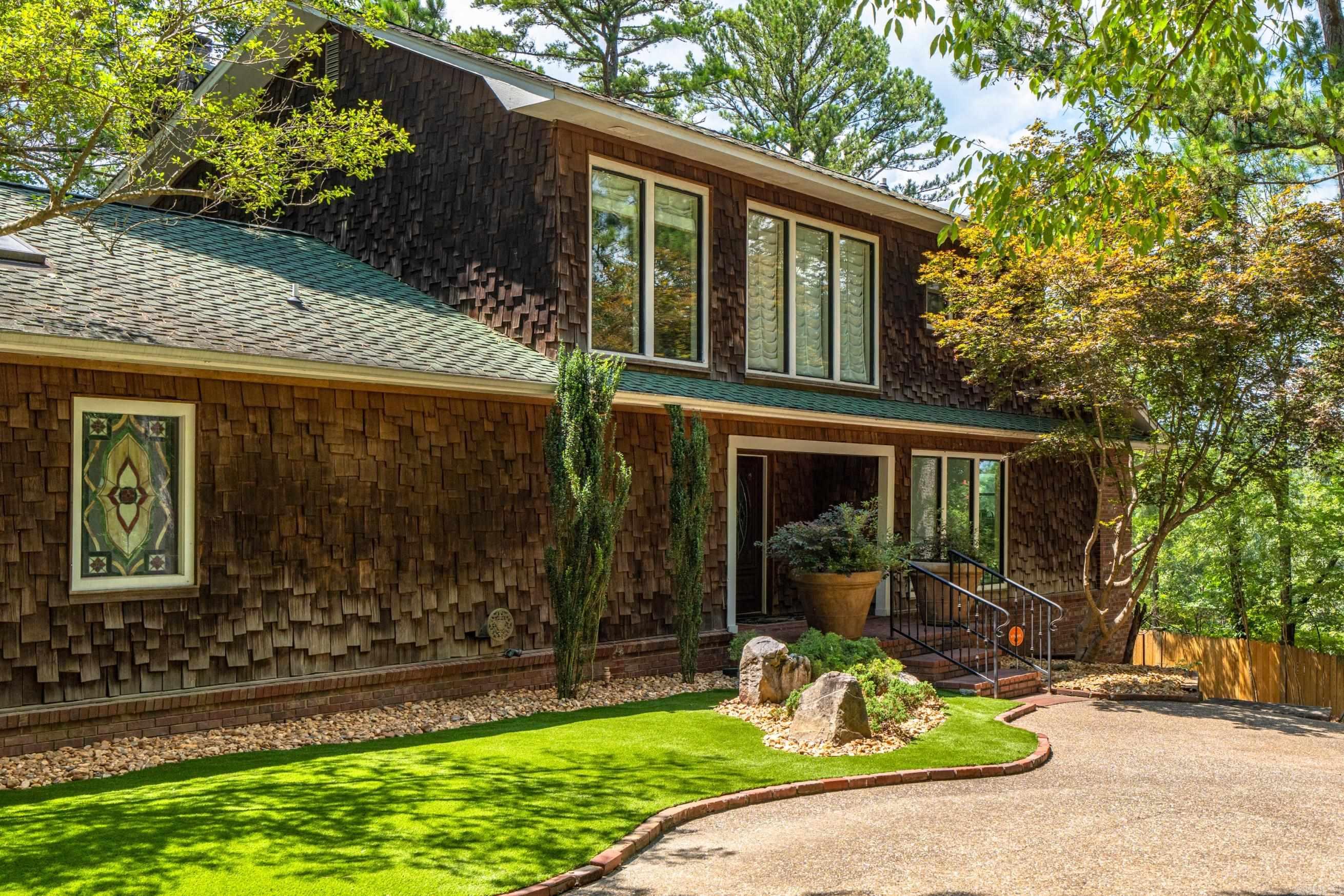 Stunning lake front lodge style home with a birds eye view of Lake Hamilton. The vaulted ceiling with wood beams and the stone fireplace give way to the wall of windows overlooking the water. The tree studded lake lot offers privacy while it frames a picture perfect view. The warm tones, wood accents and eclectic style are perfectly blended with the upscale finishes through out the home. The main home is 2735sf and offers 3 bedrooms, 2 full baths and a half hall bath plus the master 'en suite features a huge walk in shower with rain head, soaking tub and double vanities. The second story looks over the living area straight out to the water. The outdoor area is even better with a large inground pool, patio and grill area. You'll enjoy peace of mind knowing your cars and toys are safely stowed away in the large workshop garage. And to top it all off, there's a 450sf guest house that sleeps 4 or more and a full bathroom! You'll be the family favorite when your out of town loved ones come to visit and dip their toes in your little piece of paradise! Subdivision Residents have use of the community boat launch.