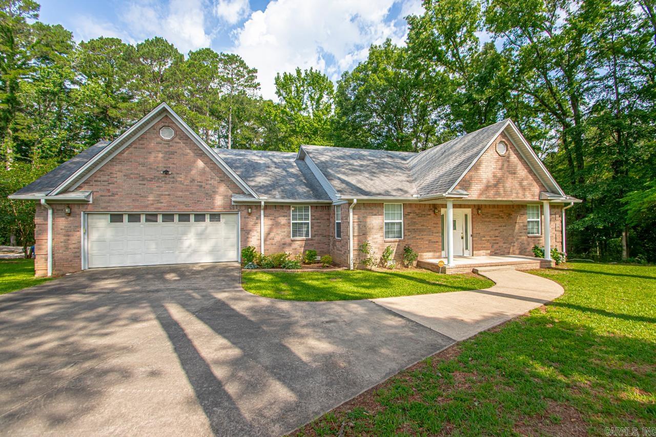 Neighborhood oasis! All the privacy and woods you want seconds from town! Pull up to a wooded corner lot with a large drive way. Go though the front door to and open foyer with private dining room to your left. Flow into the spacious living room with gas fire place and kitchen breakfast bar. The kitchen includes a wall oven and a gas surface range. on the right side of the house you will find the two guest bedrooms and a full bath. On the other side of the home you will find the spacious primary. Also on this side of the home is a 1/2 bath and huge laundry room complete with a sink! Go out back and enjoy your large 10ftx38ft back porch over looking woods and a creek. Under the home you will find a large roll up door that opens up to a storage room / workshop. Perfect for a lawn mower or fourwheeler. Make sure you set an appointment to see this one today!!