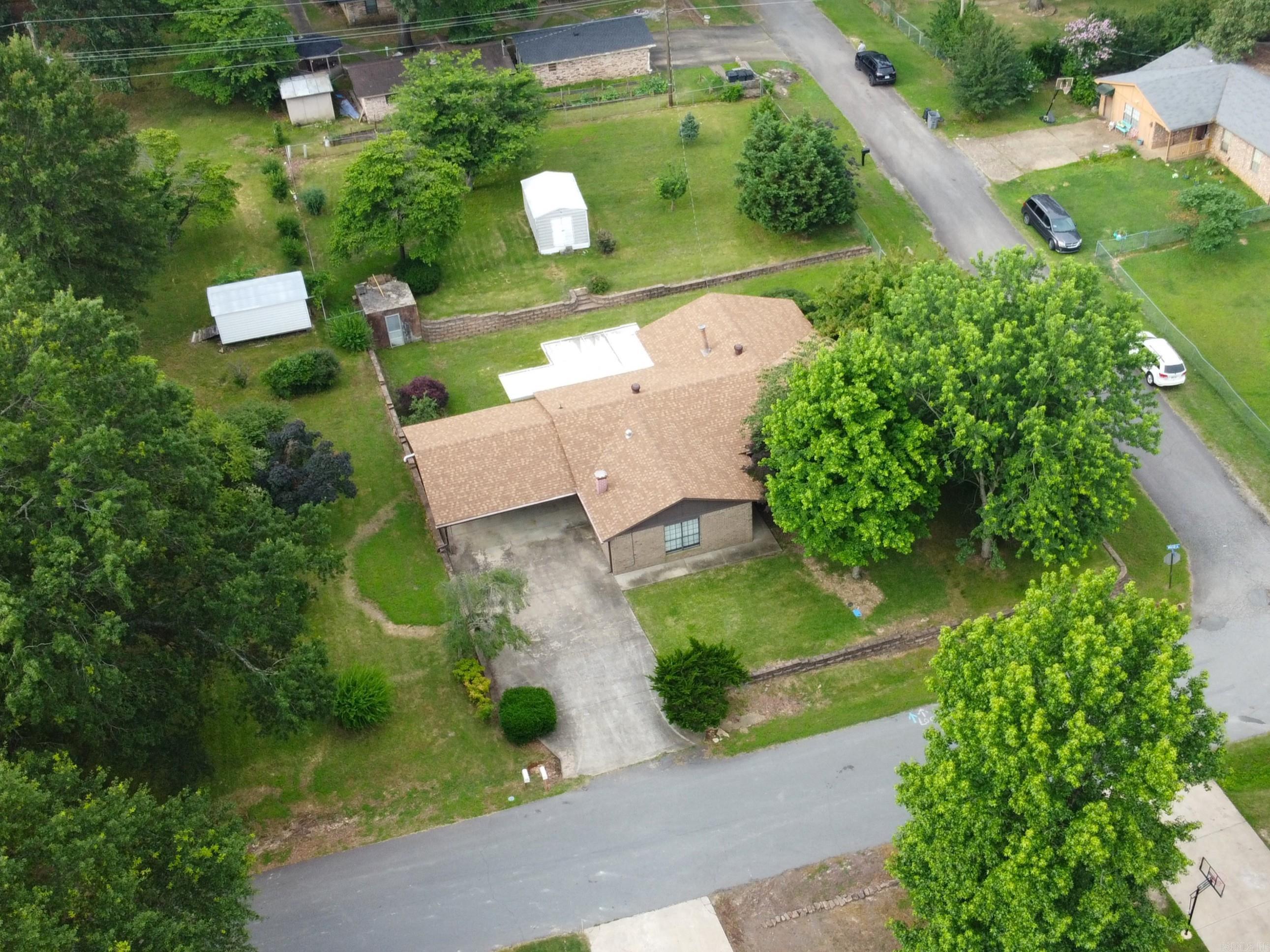 No wasted space in this well maintained home! Walk in the front door into the living room with brick fireplace. From there, step up into the kitchen and wrap around into the attached dining area with a wood burning stove. Off the dining is the enclosed patio/sunroom overlooking a large back yard with storm shelter and storage shed. Back through the dining area across to a bonus room/office/possible 4th bedroom and then make your way down the hallway to the left where you will find the primary bedroom/bathroom to the right and the full guest bathroom and two additional bedrooms are down the hallway. There is also a storm shelter and storage shed out in the backyard.