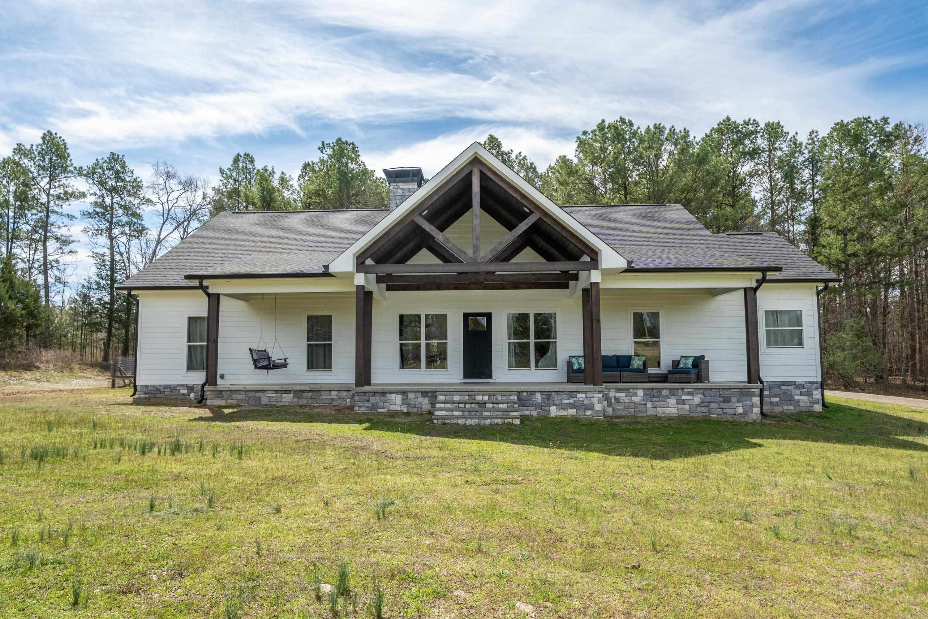 This stunning custom-built 5-bed, 2.5-bath home is perfectly situated on 4.53 acres of peaceful countryside, offering a true retreat from the hustle and bustle. The inviting front porch, complete with a charming swing, welcomes you to relax and take in the serene surroundings. Inside, the home boasts a spacious open layout w/gorgeous details like a striking stone fireplace, shiplap accents, and tongue-and-groove ceilings, creating a warm and inviting atmosphere. The chef's kitchen is a true standout, featuring high-end appliances, ample counter space, and a large pantry for all your culinary needs. A generously sized laundry room adds convenience to everyday living. Primary suite w/spacious walk-in-closet, luxurious bathroom & concrete safe room w/steel door & keypad lock. With five bedrooms and plenty of room to entertain, this home is ideal for family living, while the expansive acreage offers endless opportunities for outdoor activities, gardening, or creating your own personal oasis. Experience the perfect balance of country charm and modern luxury in this exceptional property. See Agent remarks.