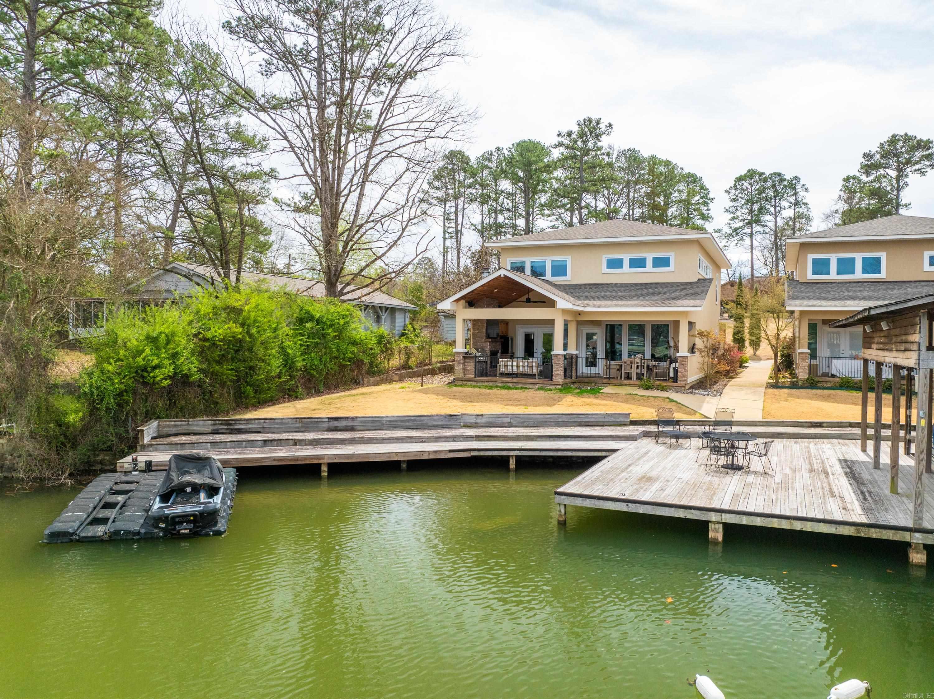 Discover this beautiful home on Lake Hamilton! Impeccably maintained, this rare opportunity features a practical layout with soaring ceilings, modern finishes, two master suites and an outdoor space ideal for entertaining or unwinding, all with breathtaking lake front views! The property includes a boardwalk with tie-ups, and access to a boat ramp. This is low maintenance lake living at its finest! Schedule your showing today!