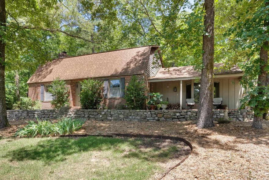 Tucked just steps from Lake Hamilton in a quiet cove near Garvan Woodland Gardens, this charming Cape Cod-style retreat sits on approx. 2.5 acres and offers endless potential. With 5 spacious bedrooms and 3 bathrooms, it's ideal for large families, corporate retreats, or a short-term rental investment. Inside, enjoy rich wood finishes and warm, inviting spaces. Sip coffee or cocktails year-round from the oversized front porch with lake views, or unwind in the private back patio surrounded by nature. The property includes a massive detached garage—perfect for RVs, boats, hobbies, or car collections. The surrounding acreage can be subdivided and developed, with incredible lakeview potential for additional STRs. Two adjacent lots are available for separate purchase, and furnishings can convey to make this a turnkey opportunity. Whether you're looking for a full-time residence, a family getaway, or a high-income rental setup, this unique lakeside property checks every box. Agents see remarks.