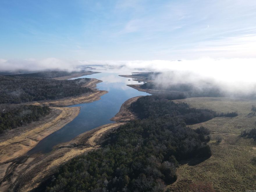 Some of the most desirable assets found in land can be uncovered as you peel back the layers of this truly amazing Ozark farm. Whether you are looking for that special lake getaway, want to farm, build a dream home, or even develop something… this place really does have it all. With over 1,000 feet of Highway 125 frontage, the access is excellent for virtually any desire. The land is a very diverse mix of rolling topography, cedar thickets, oak timber, lush pastures, hay meadows, and more. This array of God-given distinct features lends itself to multiple uses. Currently the property is being used for grazing cattle and hunting. Fencing is in place, and with some cross fencing, a more aggressive grazing operation could be implemented. As you drive in, the lush hay meadow is conveniently located with great access and produces a healthy amount of quality warm and cool season grasses. The old farmhouse has been removed, and a wonderful building site sets atop the hill with electric and water well overlooking the breathtaking vista view of Bull Shoals Lake. Rolling off the hills, the land softly cascades to wooded flats and large pastures that sweep the landscape.