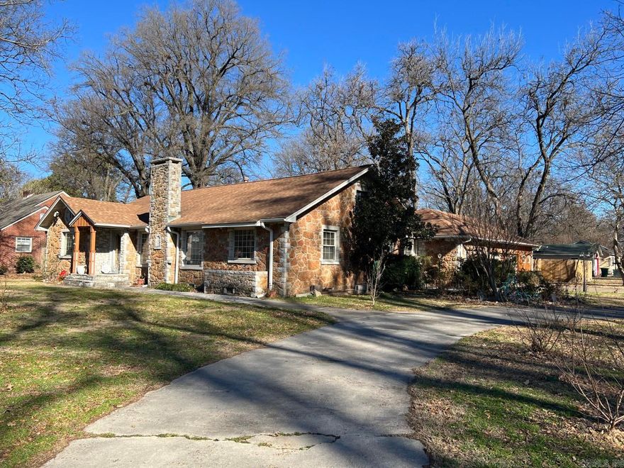 Located in Blytheville's Country Club Area, this vintage home is crafted from an unusual stone that gives it timeless character and curb appeal. The exterior is beautifully accented at the windows and the interior features some valuable updates. Inside, you’ll find a fireplace anchoring a spacious living room, three large bedrooms, and a kitchen remodel completed just five years ago. The current owner has also updated much of the plumbing under the home. New flooring was installed in the kitchen and primary suite but the lovely old hardwood still remains in much of the home. The primary bedroom is a large 18x14' and overlooks the backyard. The home sits well back from the road and includes a circular driveway off the side street, a side-entry two-car attached garage, an incorporated small shop, plus small backyard workshop. A truly unique property with character you don’t find every day.