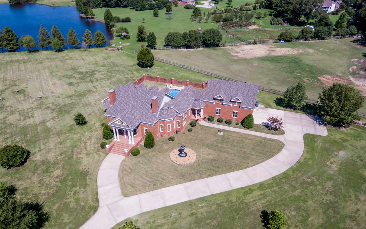 This home is truly a one of a kind custom built. Every inch of this home has been planned out to the smallest detail and expertly constructed by David Onstead. From the moment you drive thru the private, gated entrance you will know without a doubt you are experiencing an exquisite estate. This lake front property is situated on a well groomed 6.78 acre lot, the double doors invite you into the foyer which looks out the back of the house to the inviting in ground pool covered patio.