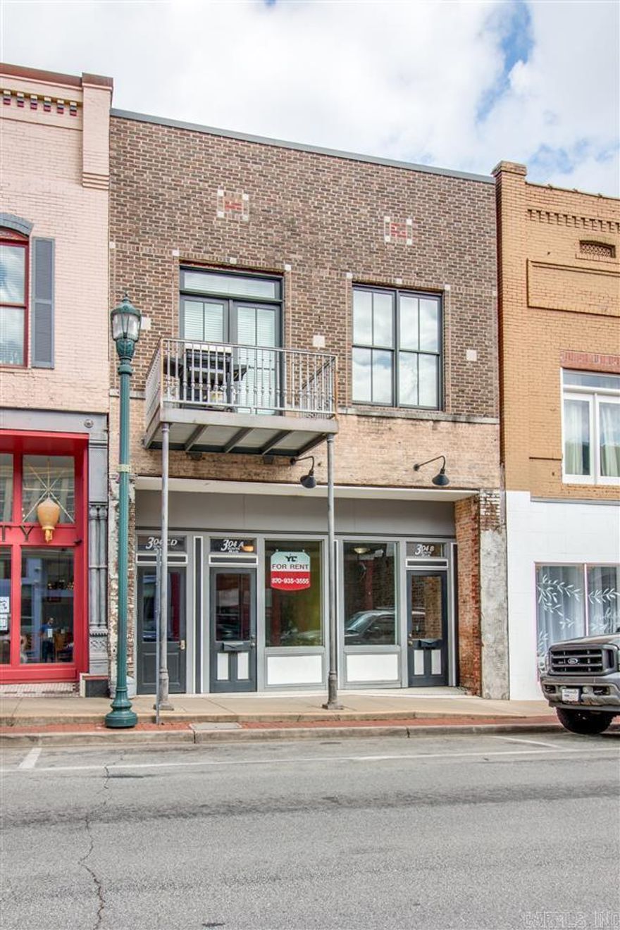 Welcome to the Rental Market 304 S. Main St., Ste A of Downtown Jonesboro, AR. A historic gem, rich in character and history. Location, location, location! This property is located across the street from Omar's Uptown and surrounded by professional offices, and fine retail & dining establishments. Conveniently located with quick access to anywhere you need to be in town. The front exterior features a contemporary color palette of black, white, and gray and offers a large store front window for displays. Around back there is an additional entrance to the building and a common use deck. Inside you will find 900 sf. of well laid out and usable space. A front reception/lobby area followed by a long and wide space for desks. The lounge area holds a half bath, eating area, refrigerator, sink, cabinets, and countertop space. There is plenty of space for storage with two large storage rooms. Designed and crafted with love, this one of a kind retail space offers soaring high ceilings, gorgeous chandeliers, a rich color scheme, original hardwood floors, and is wired for your business needs. Schedule your tour and sign your lease. Owner is a licensed real estate broker.