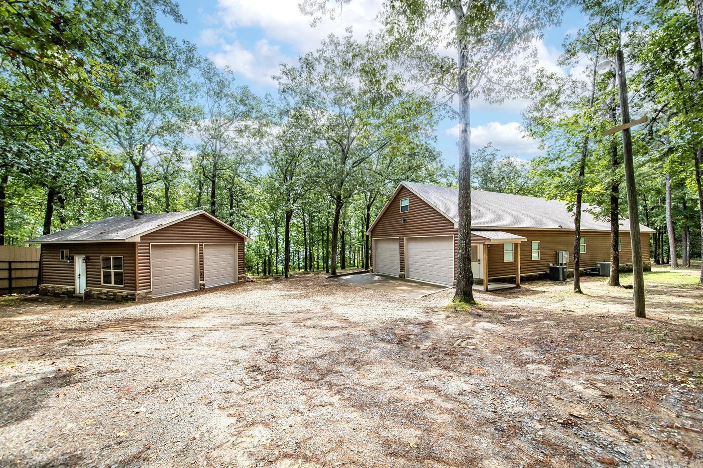 This beautiful cabin-style home offers the perfect blend of rustic charm & modern comfort. This property comes complete with lake views &a boat slip! Step inside this quality-built lake front home & be greeted by an inviting & cozy atmosphere. The open-concept living area features tall ceilings& large windows that flood the space with natural light, offering stunning views of the lake from many angles. Imagine waking up to the sound of gentle waves &sipping your morning coffee while taking in the serene beauty of the water. The spacious kitchen is just what you've dreamed of & you'll also find a delightful outdoor cooking space, ideal for hosting summer barbecues & enjoying alfresco dining with family & friends. After a day of boating & water activities, gather around the fire pit in the private backyard oasis. Roast marshmallows, share stories, & create lasting memories while enjoying the warmth of the crackling fire under the starry night sky. Retreat to the master suite, a tranquil haven featuring a luxurious ensuite bath & a private sunroom overlooking the lake.Whether you enjoy fishing, boating,or simply relaxing on the water, this lakefront paradise has it all. See it today!