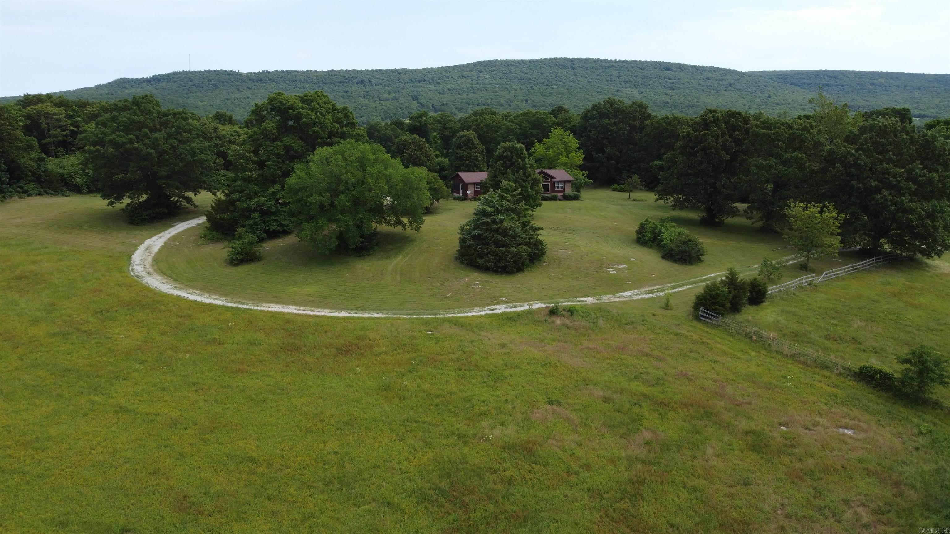 Idyllic 80 acre farm with 4 BR-3 BA, 3,014 SQFT home!! This one-owner home features cathedral ceilings, floor-to-ceiling living room windows, walk-in closets, a galley kitchen, large screened in porch, beautiful brick fireplace with wood insert, and wood stove. The 80 acres feature about 25 acres of pasture with 2 fenced areas, two ponds, and a large machine shed. Deer, bear, turkey, and elk have been seen on the property. Excellent hunting, seasonal creek, rolling topography, private location, and all home appliances and gun safe convey. Approximately 25 minutes into Harrison.