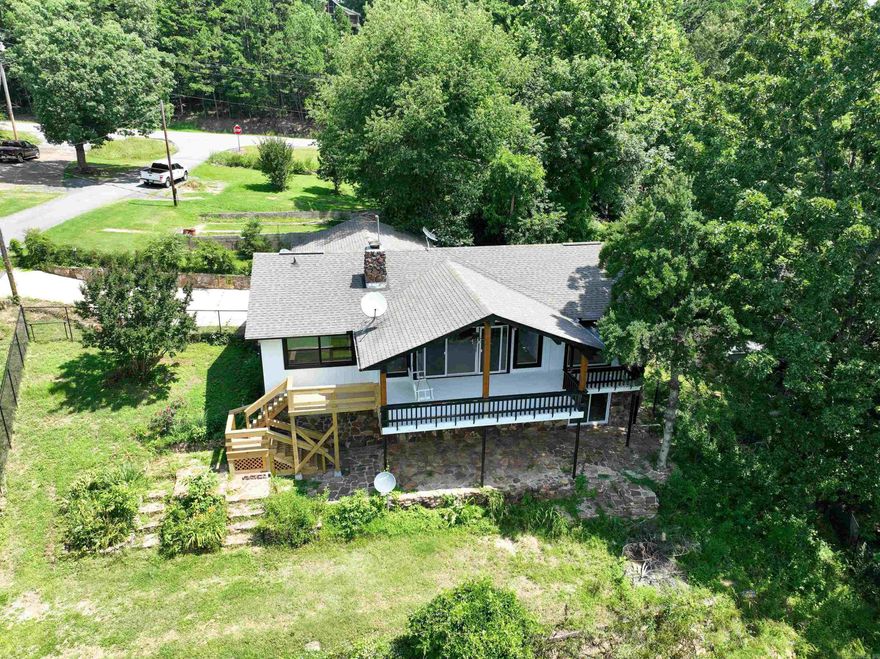 Lake views and fully remodeled! This 4-bedroom, 3-bath home is just 2 miles from Devil’s Fork Marina. The main level features vaulted ceilings, a cozy wood-burning fireplace, and luxury vinyl flooring. Enjoy the master bedroom with ensuite bath and balcony access, plus a guest bedroom and full bathroom and large dining room area. Downstairs, you'll find two more bedrooms, a full bath, and a finished basement with a game room and spacious living area plus a wet bar. Enjoy the large back patio overlooking Greers Ferry Lake, a big fenced yard, two-car carport, and two outdoor sheds. Recent updates include a new roof, HVAC, water heater, paint, light fixtures, and decking. Move-in ready and perfect for lake living!