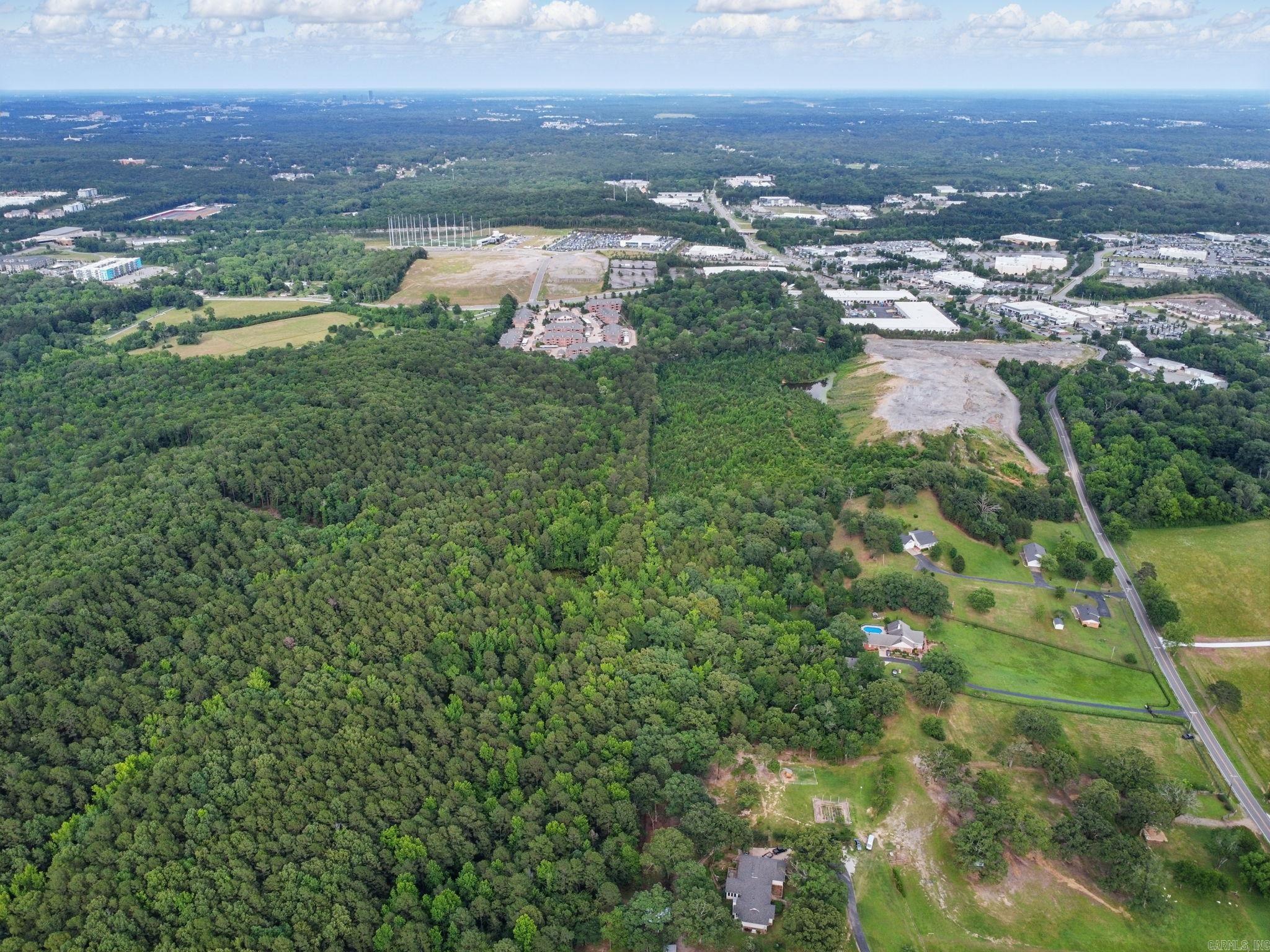 ATTENTION DEVELOPERS~ This exceptional wooded, hilltop tract in West Little Rock presents an ideal opportunity for luxury residential development. Located approximately one mile west of the Colonel Glenn Exit on I-430, the property offers a perfect blend of seclusion and accessibility. The site features panoramic views from multiple vantage points, particularly from the east/west ridge at 500 feet elevation, creating stunning backdrops for either a large-lot residential community or an exclusive estate-style homesite. The natural topography includes a charming small pond and two primary ridges that provide excellent opportunities for strategically placed large lots designed for maximum aesthetic appeal. Essential utilities are readily accessible, with municipal water service and electricity easily available, plus the area benefits from high-speed internet connectivity. A sample lot layout is available to demonstrate the development potential.