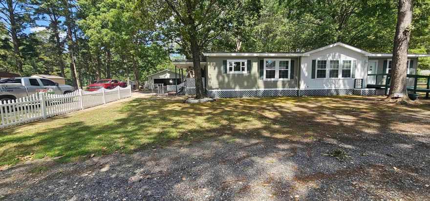 Check out this spacious 3-bedroom, 2-bathroom double wide home out of town! This well-maintained home features a large den and expansive kitchen area, ideal for family gatherings or entertaining guests. The generous master suite includes a huge walk-in closet for ample storage. Outside, enjoy a covered back patio for relaxing or outdoor dining, a mostly fenced-in yard great for pets or privacy, a detached 2-car garage, and two additional storage areas for tools or hobbies. With an open and airy floor plan filled with natural light, this home combines rural charm with modern convenience.