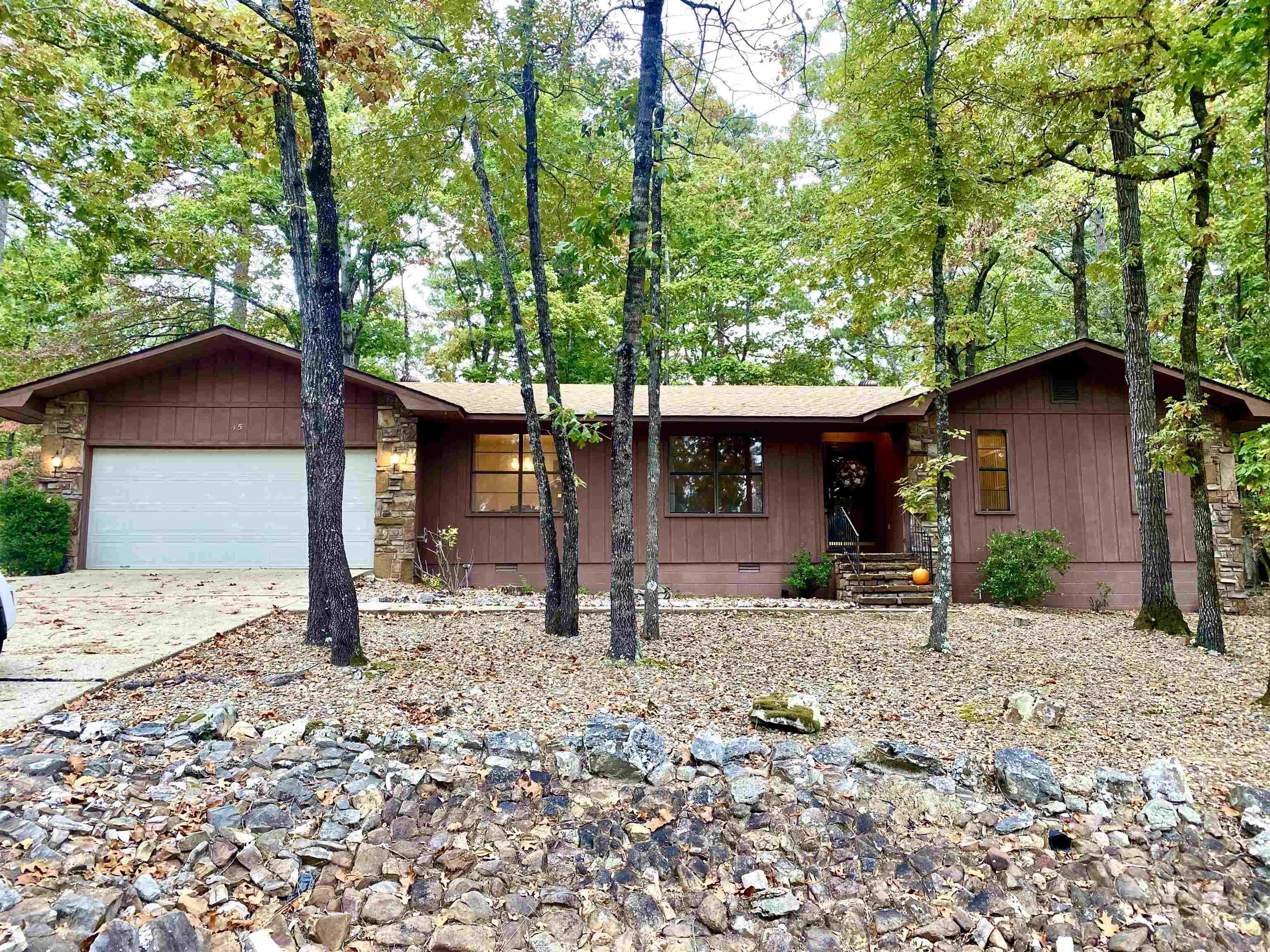 OPEN HOUSE SUNDAY 2-4pm! This late 70's built home is so WELL PRESERVED, you'll feel like a kid again. It has All the cool 70's features, and an earthy "cabin" feel that's very cozy and warm. The slate floor entry is so inviting, as well as the large stone fireplace with wonderful built ins. The kitchen will have you reminiscing with the mint condition butcher block countertops and cool hardware...and the show stopper is the saloon doors going into the dining room. The large sliding glass door in the den takes you out to a BRAND NEW 20 foot DECK...a great place to relax and enjoy nature. Two bedrooms are down the hall and the primary has an en-suite bathroom. You'll appreciate the spacious laundry room with it's own back door, plus a large two car garage. Lake DeSoto is just a short two minute walk, and offers a nice fishing dock. Or bring your golf cart and head to the DeSoto Golf Course nearby.  Come fall in love with the 70's all over again, this home is amazing, and its comes with a new roof and hvac too!