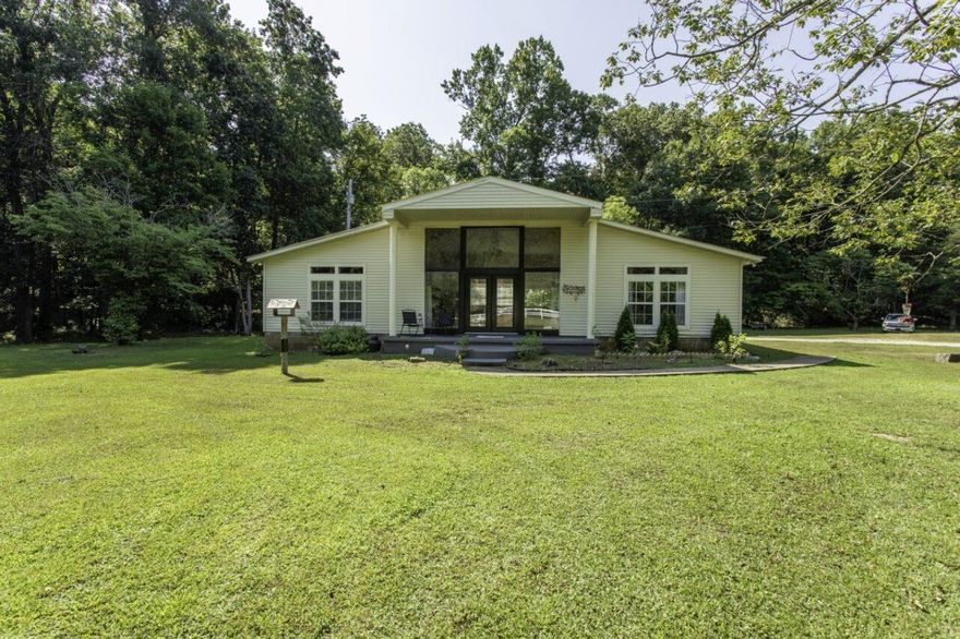 Country Home on 21 Acres Near Hardy, AR!  This 2-bedroom, 2-bath home, located in Sharp County, Arkansas, offers privacy with convenient access to town. Built in 2001, the 1,456 sq ft m/l vinyl siding home features a split floor plan and an open-concept living and kitchen area with a cathedral ceiling. The home includes a metal roof (approx. 10 years old), a small front porch, and a rear concrete patio.  This country home is mostly wooded, with a creek running along one side of the property and also offers a small hunting cabin, making it well-suited for outdoor recreation and deer hunting. Located on a blacktop road, the property is approximately one mile from Hardy, Arkansas and the Spring River. Enjoy a peaceful country setting that still feels close to town in the heart of Ozark Mountains & Spring River Country.