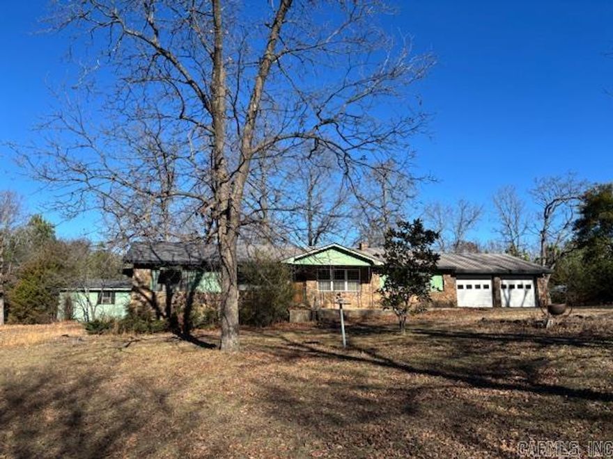 Great homesite for this late 70s 3 or 4 bedroom 2 bath home on 8 acres m/l. Large living room with wood floors and large brick flue providing architectural interest. Bonus room for office or 4th bedroom, etc. Large yard with mature trees, 2 sheds, and an animal shed with enclosure for smaller animas. Mostly level to gently rolling acreage fronts country road. Great location between Yellville and the Buffalo River.