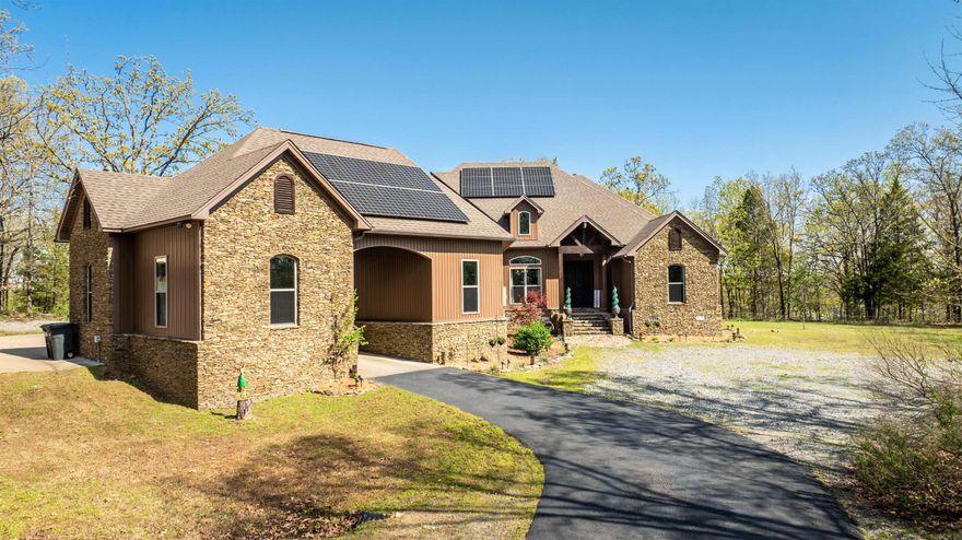 Private, custom-built home on over 13 wooded acres with 3 beds, 3.5 baths, office, bonus room with full bath, and 3-car garage. Open floor plan features hardwood floors, granite countertops, and wood-burning stacked-stone fireplace. Kitchen includes pot-filler and ample cabinet space. Spacious primary suite with soaking tub and walk-in shower. Jack-and-Jill bath between 2nd and 3rd bedrooms, each with walk-in closets.  Outdoor living includes a partially covered deck with outdoor TV. Additional amenities: 24x40 shop, barn w/ electric & water, RV parking with 2 hookups, whole-home generator, solar panels, storm shelter, and hot water spigot outside. Wooded acreage  = mostly maintenance free! Room to build additional home(s), buildings, pool, etc... Located outside of city limits, no restrictions.  Ideal for buyers seeking space, privacy, and modern comforts—move-in ready with room to grow.