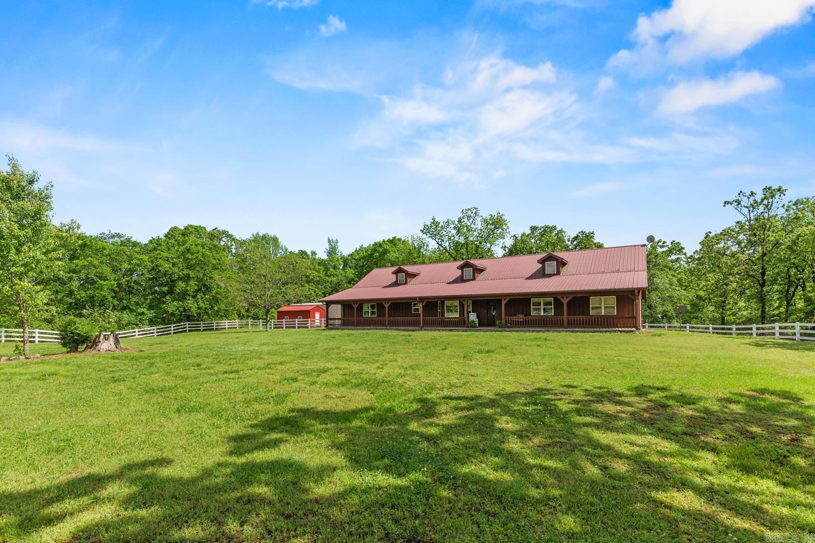 Spacious 4-Bedroom Home on Nearly 10 Acres with Shop and Storage – A Rare Find! This well-maintained 4 bedroom, 2.5 bath home offers nearly 2,700 square feet of comfortable living space on 9.94 mostly wooded acres, blending privacy with convenience. Inside, you'll find central heat and air, a welcoming front porch, cozy fireplace, a two-car attached garage. The kitchen features abundant custom cabinetry, stainless steel sink, wall oven, electric cooktop, and it opens to a large dining room, perfect for family meals or entertaining. The spacious den is large enough to accommodate a pool table or media area. Enjoy security and peace of mind with a built-in ADT alarm system. Step outside to the back deck or relax in your fenced backyard, newly enclosed with a white PVC privacy fence. The property also includes a red iron 30x40 shop with a concrete apron, ideal for hobbies, equipment, or extra storage, as well as a new storage building. Whether you're looking for a quiet homestead, place to spread out, home with shop space, wooded acreage, this checks all the boxes. Call to schedule your private showing! Call Listing Agent and potentially save thousands on extra buyers agency fees.
