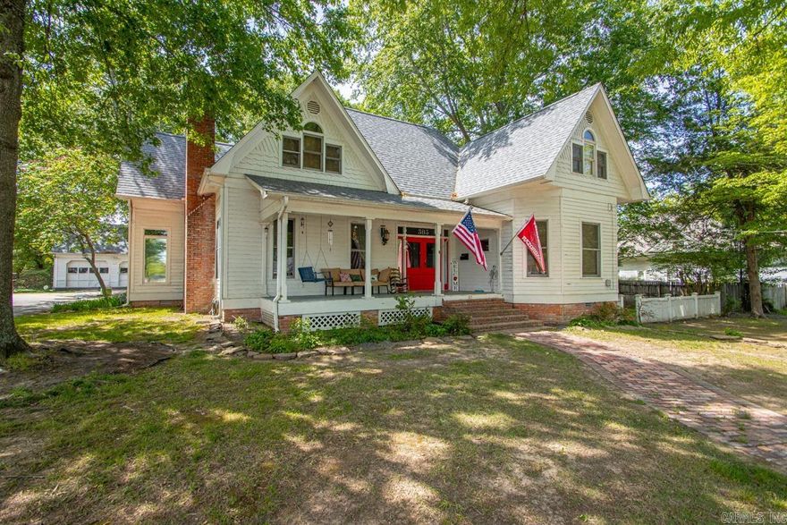 This stunning 1994-built Victorian masterpiece perfectly blends timeless historical charm with modern structural integrity. The inviting front porch welcomes you into an expansive main level featuring soaring ceilings and a thoughtfully redesigned kitchen complete with premium granite countertops and a sunny breakfast nook. Entertaining is effortless with a dual-sided fireplace layout warming both the formal dining room and the spacious living area. The main-floor primary suite serves as a true retreat, boasting an oversized bedroom, a massive walk-in closet, and a luxurious bathroom anchored by a Jacuzzi tub. Upstairs, you will find three additional bedrooms, a full bath, and a versatile unfinished bonus space ready to be customized for extra square footage. The property is rounded out by an oversized detached two-car garage and a serene screened-in back porch, offering the ultimate setting for outdoor relaxation and guest hosting. Property needs a little TLC.  SEE REMARKS - SOLD AS IS