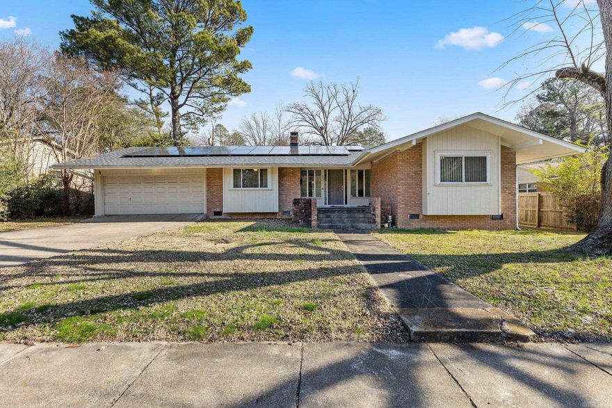 Upon entering your front door, you will immediately feel at home in the spacious living room, which is made cozy by a gorgeously tiled fireplace. As you walk across the porcelain tile hardwood floors you will be drawn to your oversized kitchen, equipped with stainless steel appliances and a chef's stove. Your quartz countertops will make meal preparation a delight, and the breathtaking backsplash will captivate your attention. Your beautiful home features 3 large bedrooms and 2 full baths, with the second bath conveniently located in the primary suite. The white tile walk-in shower in the primary suite  provides a comforting warmth after a long day of work. You will appreciate the separate laundry room and the abundance of closet and cabinet storage throughout your  home. The large garage also includes a workshop area perfect for those who enjoy DIY projects. Your spacious backyard boasts a patio where you can spend many enjoyable evenings. To add to the appeal, this home has a new roof, and is equipped with a premium array of solar panels, resulting in significant savings on future electric bills. (Buyer will assume the Solar Panel contract).