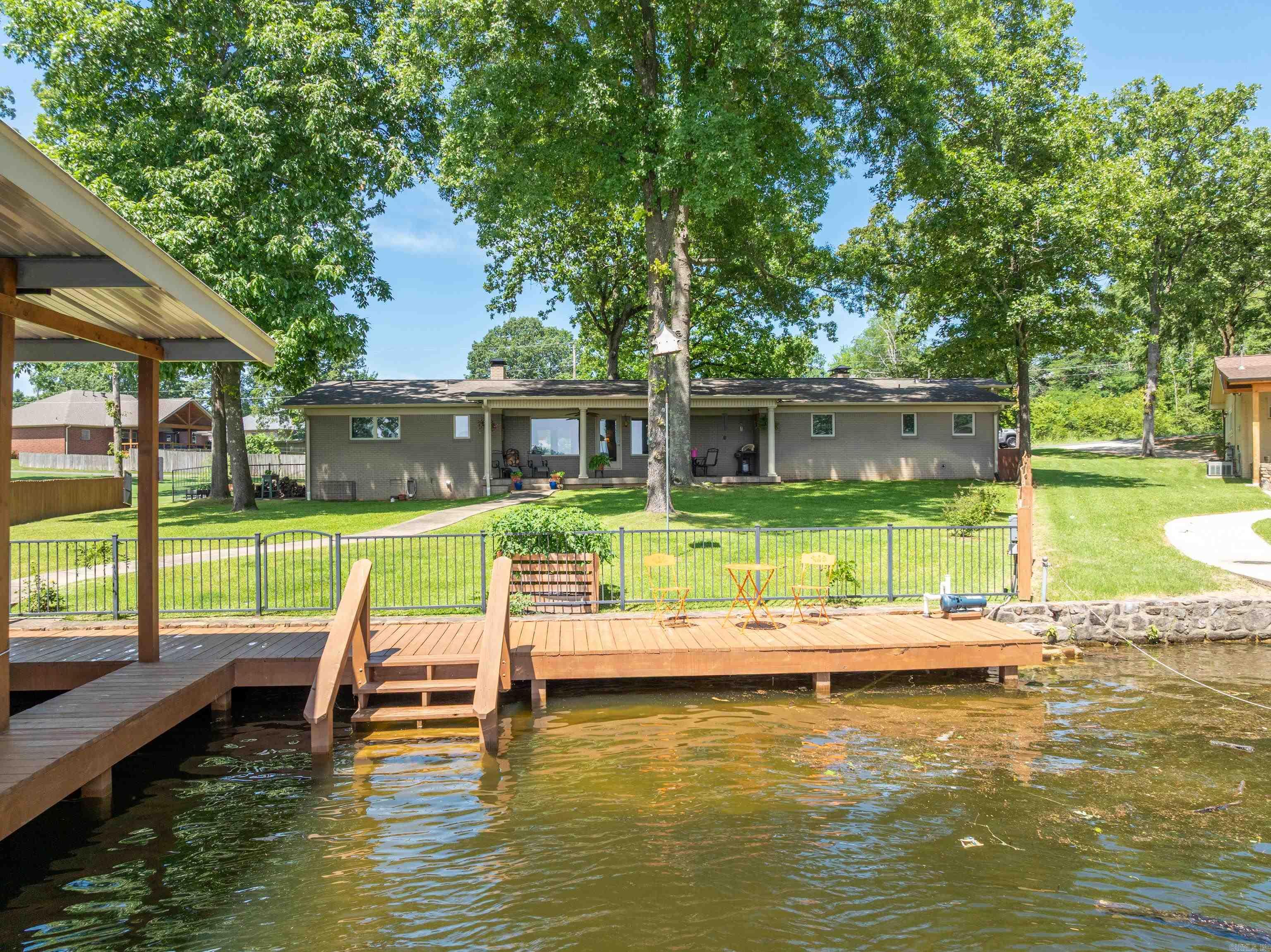 This exceptional lakefront property offers a blend of timeless charm and contemporary convenience, thoughtfully enhanced by meticulous landscaping. Each bedroom boasts its own en-suite bathroom, lending an air of privacy and sophistication, while two spacious living areasāeach featuring a wood-burning fireplaceācreate a warm and inviting ambiance ideal for gatherings and quiet evenings alike. The kitchen is a culinary enthusiastās dream, outfitted with premium appliances including a Sub-Zero refrigerator, a gas stove, and a built-in ice makerāan elegant and functional space designed to inspire. The inclusion of a private boat dock and lift elevates the experience of lakeside living, allowing effortless enjoyment of all that Lake Hamilton has to offer. Recent improvements, such as new shingles and gutters installed in 2023, reduce ongoing maintenance concerns, and the addition of a whole-home generator and a new tankless water heater in 2024 offers peace of mind. This remarkable home is a must-see for anyone seeking the full Lake Hamilton lifestyle.