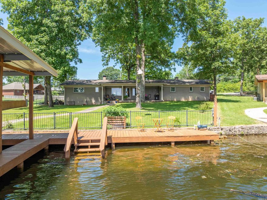 This exceptional lakefront property offers a blend of timeless charm and contemporary convenience, thoughtfully enhanced by meticulous landscaping. Each bedroom boasts its own en-suite bathroom, lending an air of privacy and sophistication, while two spacious living areas—each featuring a wood-burning fireplace—create a warm and inviting ambiance ideal for gatherings and quiet evenings alike.  The kitchen is a culinary enthusiast’s dream, outfitted with premium appliances including a Sub-Zero refrigerator, a gas stove, and a built-in ice maker—an elegant and functional space designed to inspire. The inclusion of a private boat dock and lift elevates the experience of lakeside living, allowing effortless enjoyment of all that Lake Hamilton has to offer.  Recent improvements, such as new shingles and gutters installed in 2023, reduce ongoing maintenance concerns, and the addition of a whole-home generator and a new tankless water heater in 2024 offers peace of mind.   This remarkable home is a must-see for anyone seeking the full Lake Hamilton lifestyle.