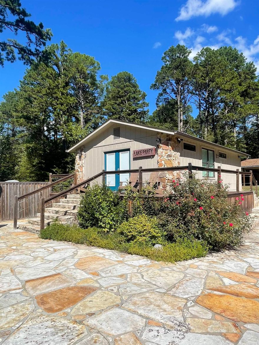 RARE OPPORTUNITY to be in Interlochen Estates on Greers Ferry Lake. Main house burned. Property currently has a super cute, furnished guest house and 16x20 storage shed with 16x28 covered area for parking lake toys, lawn mowers, side by sides, etc. Concrete driveway with flagstone drainage path beside driveway. Flagstone sidewalk and back patio area, along with a stone outdoor fireplace. 8x8x8 safe room. Beautiful yard also features sod, a sprinkler system, uplights at the trees, a stacked stone fire pit, wood privacy fence, and circle driveway. Has lake view.