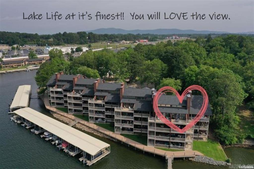 Lake Hamilton’s Ultimate Waterfront Condo – Where Luxury Meets Serenity! Experience lakeside living at its finest in this exquisite top floor, 2-bedroom, 2-bath condo with a stunning loft space featuring a king-sized bed—perfect for guests or a cozy retreat. Nestled in Hot Springs’ most sought-after 7 South location, this property offers unmatched beauty and convenience. From the moment you step inside, you’ll be captivated by the soaring vaulted ceilings and a wall of windows that frame breathtaking water and mountain views. Thoughtfully redesigned and remodeled from top to bottom to capture every inch of space, each detail has been meticulously curated with premium finishes to elevate your living experience. Whether you’re savoring morning coffee on the balcony or unwinding after a long week this is the place to enjoy the magic of Lake Hamilton. Comes with your very own covered boat dock, private covered parking, swimming pool & hot tub, balcony access to the waterfront boardwalk – and is selling with the furnishings. For those who value energy efficiency, the geothermal heating and cooling system ensures year-round comfort while keeping utility costs in check. Plus, the one-ye